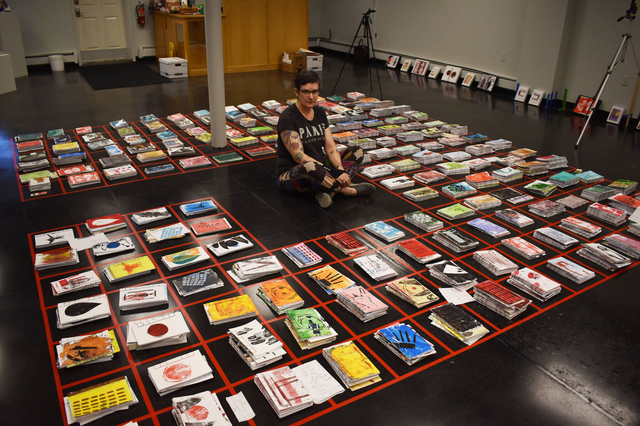 Jake Dye / Peninsula Clarion 
Diane Dunn sits, surrounded by 2,000 journals she made and painted by hand, on Tuesday, ahead of the opening of “2000 Journals: Filling the Void” at the Kenai Art Center.
