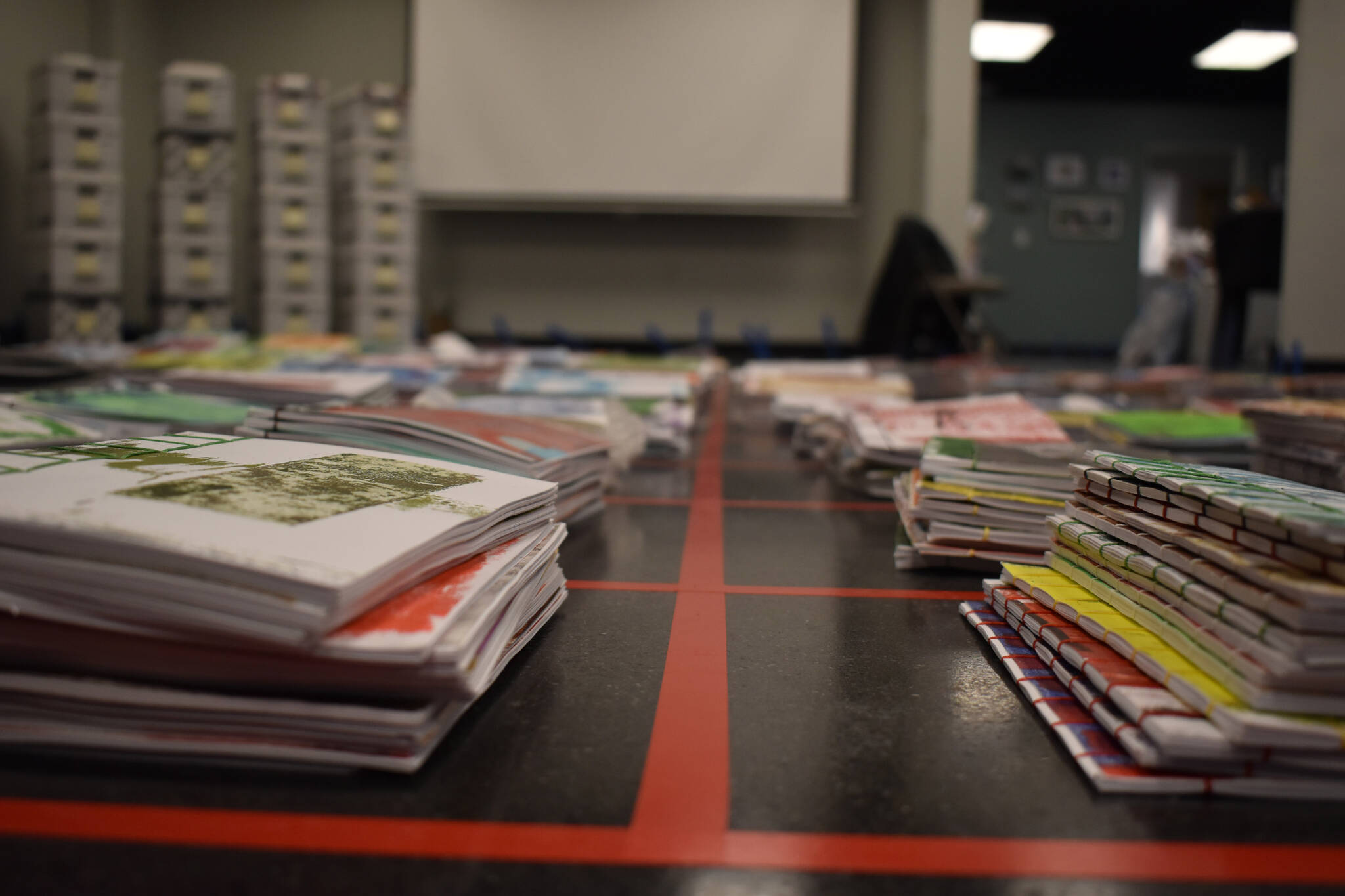 Stacks of journals cover a large space of the floor on Tuesday, Jan. 3, 2023, ahead of the opening of Diane Dunn’s “2000 Journals: Filling the Void” at the Kenai Art Center in Kenai, Alaska. (Jake Dye/Peninsula Clarion)