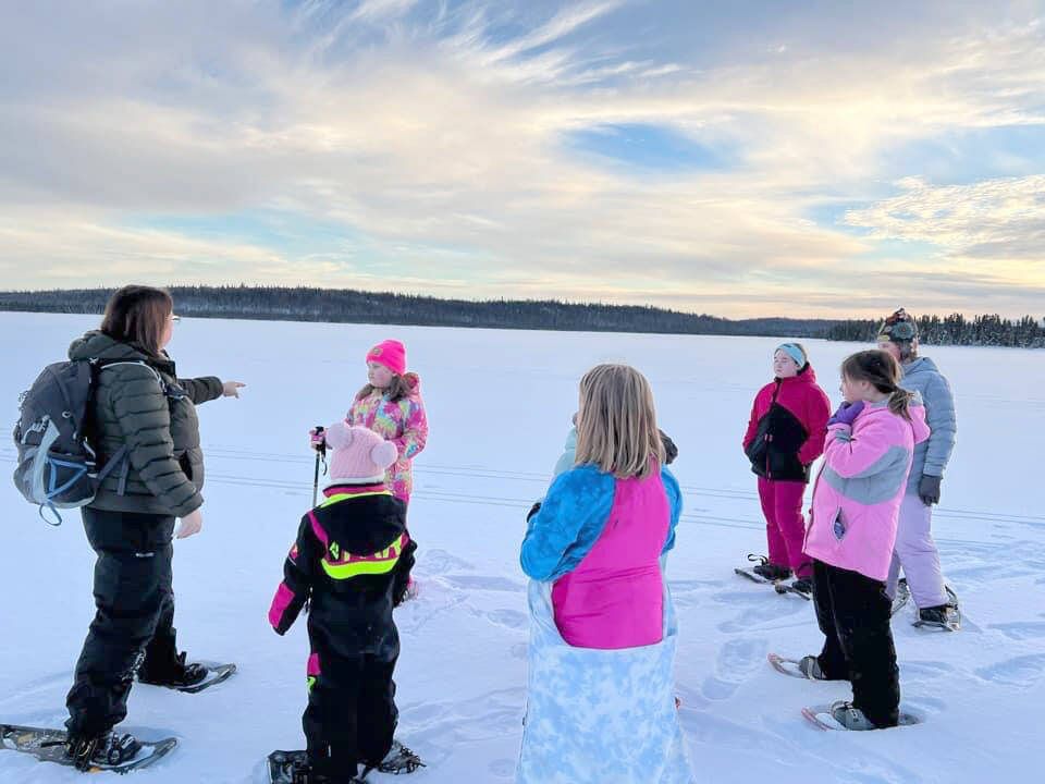 Snowshoers talk with Ranger Leah Eskelin during a December snowshoe walk at the Kenai National Wildlife Refuge. (Photo by Catie Shelden)