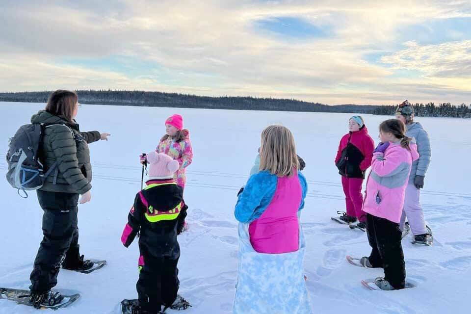 Snowshoers talk with Ranger Leah Eskelin during a December snowshoe walk at the Kenai National Wildlife Refuge.  (Photo by Catie Shelden)