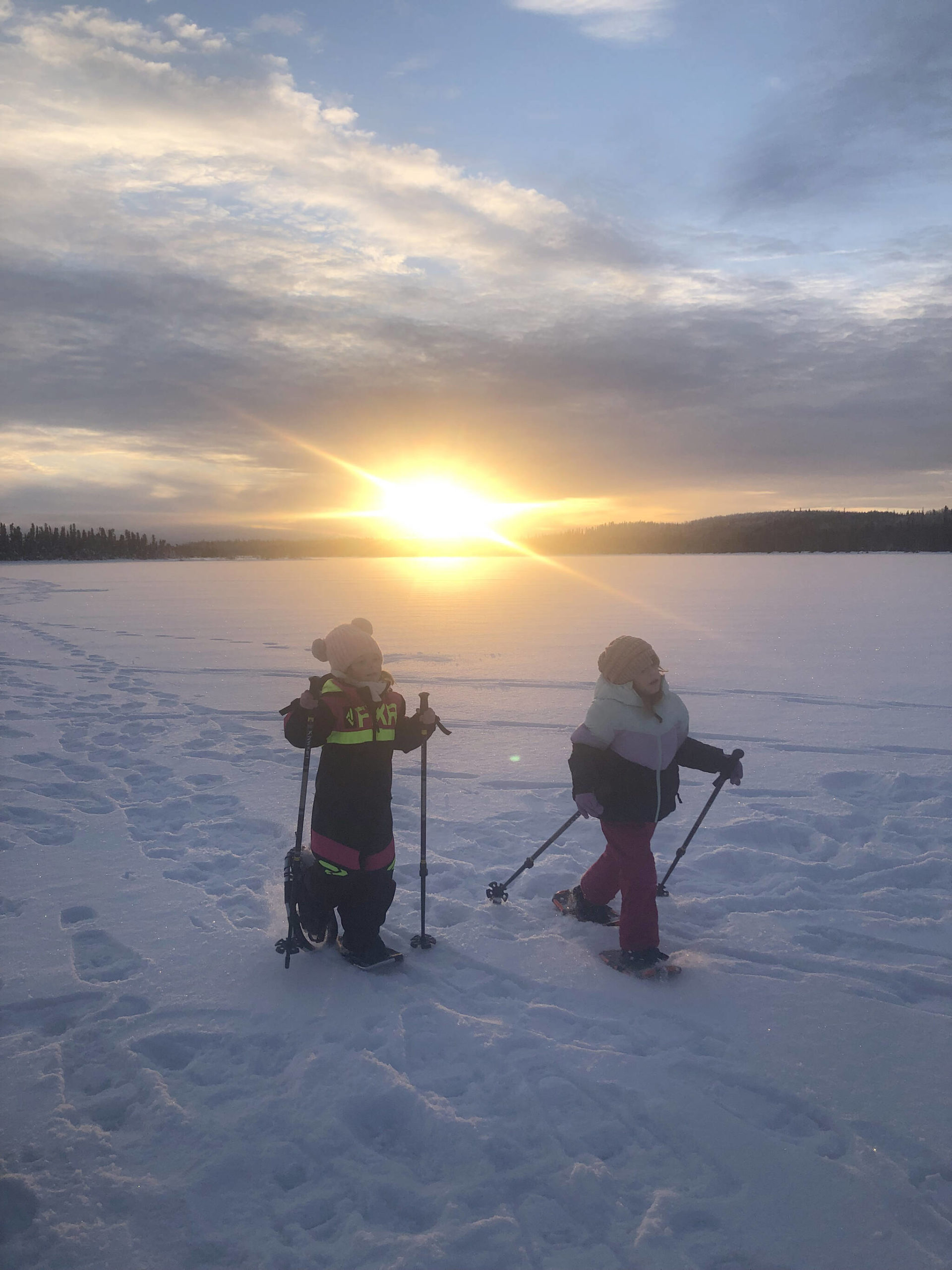 Two young snowshoers make their way across Headquarters Lake during a ranger-led snowshoe walk. (Photo by USFWS)