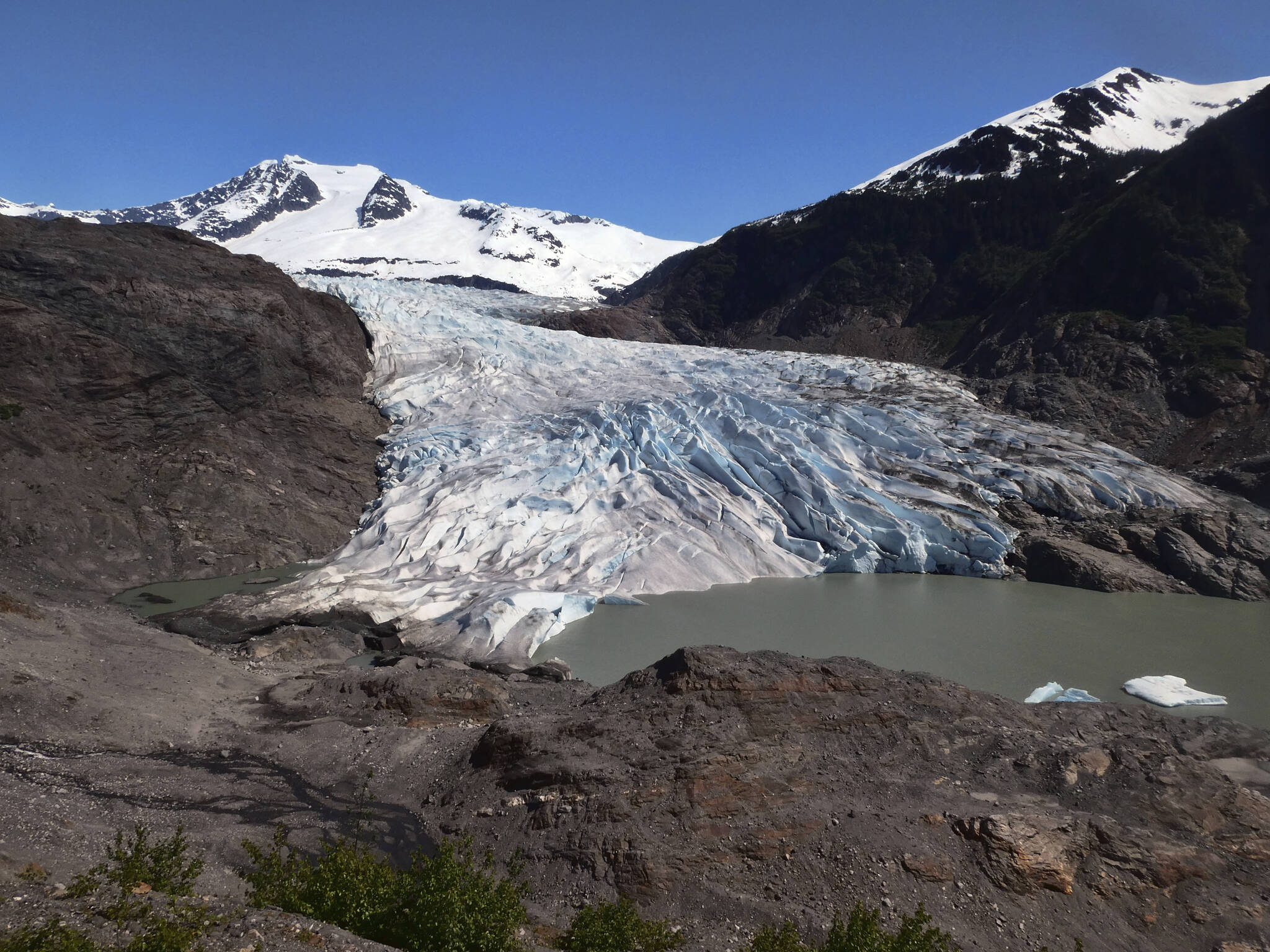 Chunks of ice float on Mendenhall Lake in front of the Mendenhall Glacier on Monday, May 30, 2022, in Juneau, Alaska. A study of all of the world’s 215,000 glaciers published on Thursday, Jan. 5, 2023, finds even if with the unlikely minimum warming of only a few tenths of a degrees more, the world will lose nearly half its glaciers by the end of the century. With the warming we’re now on track to get, the world will lose two-thirds of its glaciers and overall glacier mass will drop by one-third while sea level rises 4.5 inches just from melting glaciers. (AP Photo/Becky Bohrer)