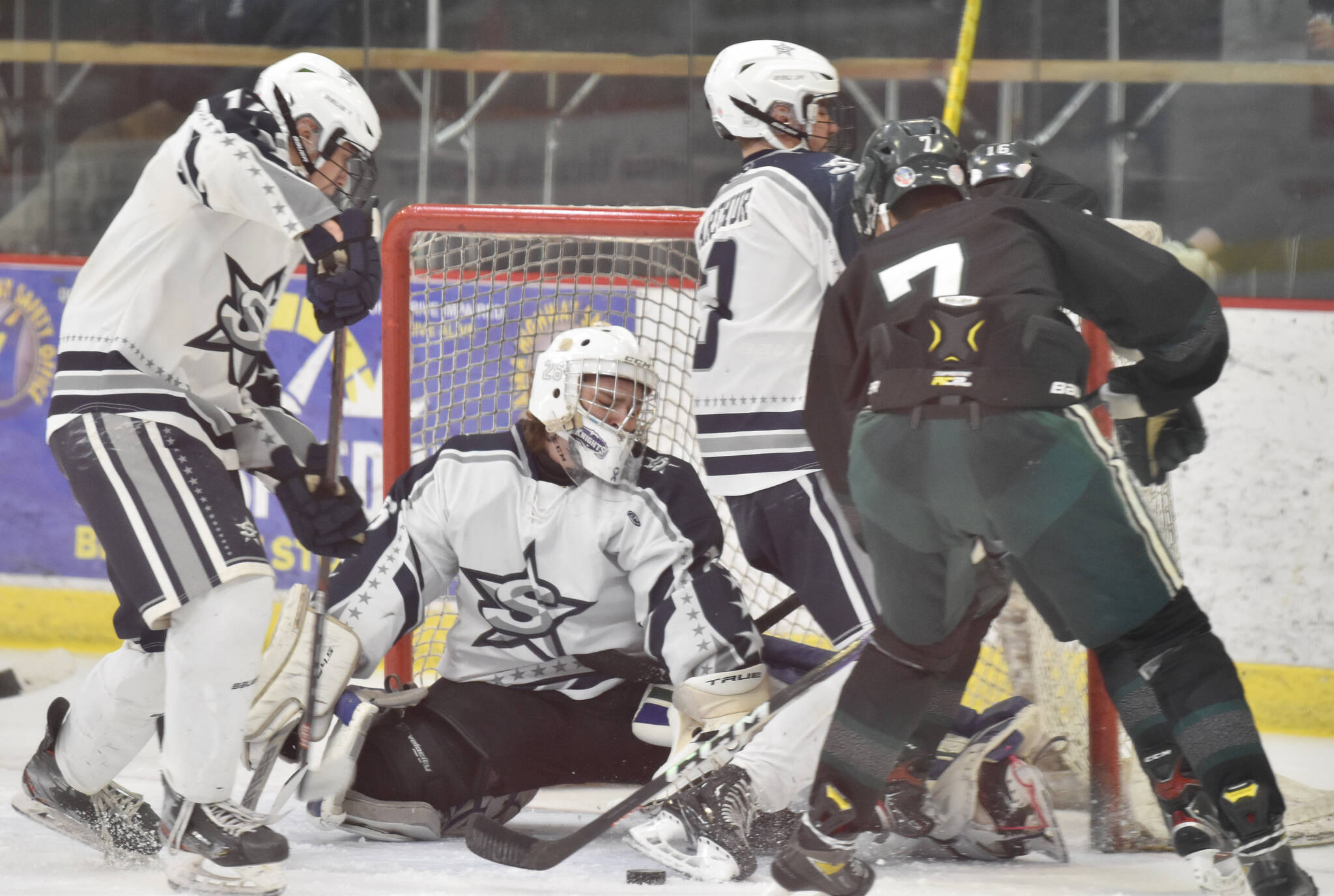 Soldotna goalie Jackson Purcell makes a save in front of defesenmen Aiden Burcham and Andrew Arthur and Colony’s Jerad Hacker on Saturday, Jan. 7, 2023, at the Soldotna Regional Sports Complex in Soldotna, Alaska. (Photo by Jeff Helminiak/Peninsula Clarion)