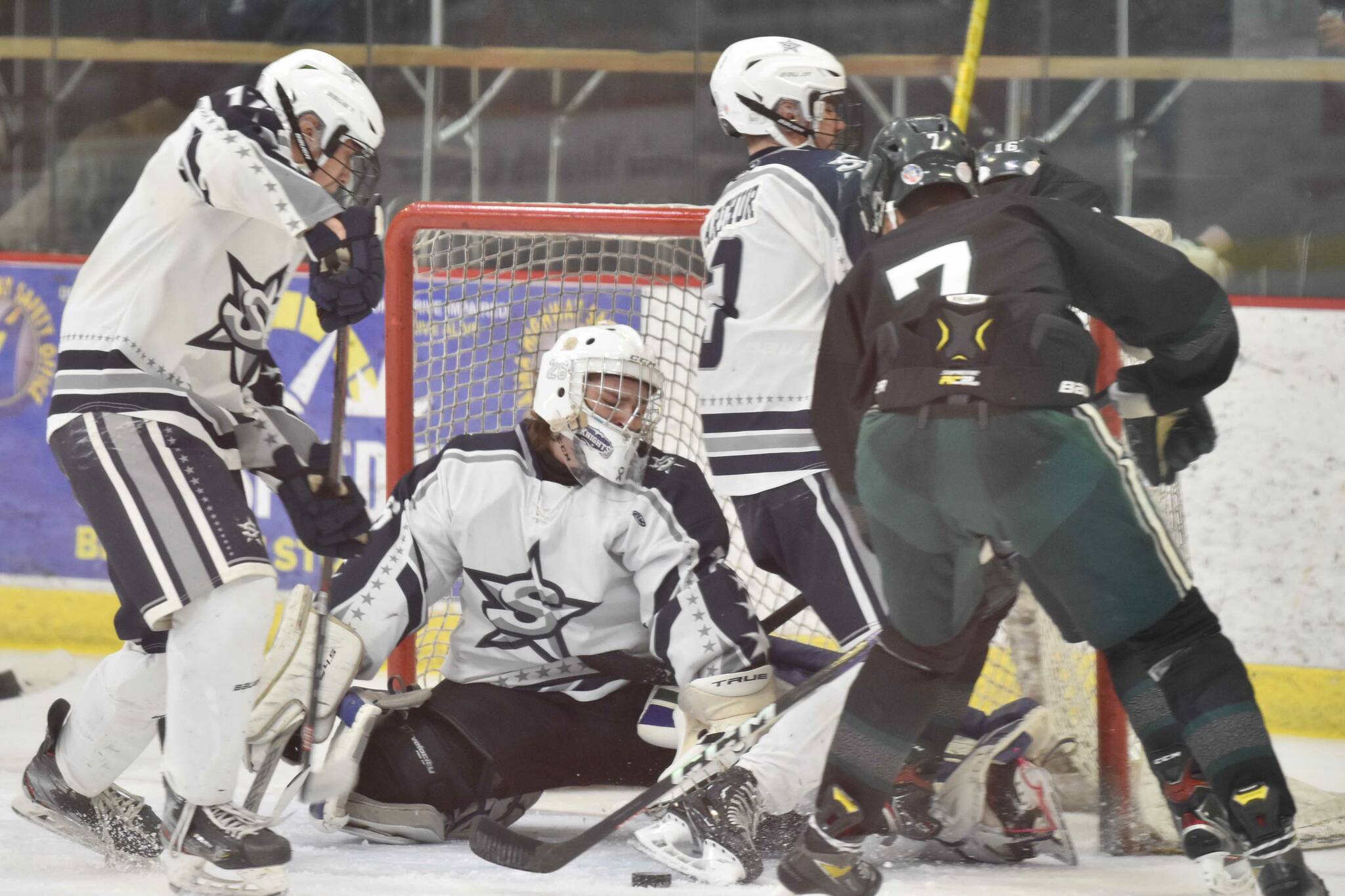 Soldotna goalie Jackson Purcell makes a save in front of defesenmen Aiden Burcham and Andrew Arthur and Colony's Jerad Hacker on Saturday, Jan. 7, 2023, at the Soldotna Regional Sports Complex in Soldotna, Alaska. (Photo by Jeff Helminiak/Peninsula Clarion)