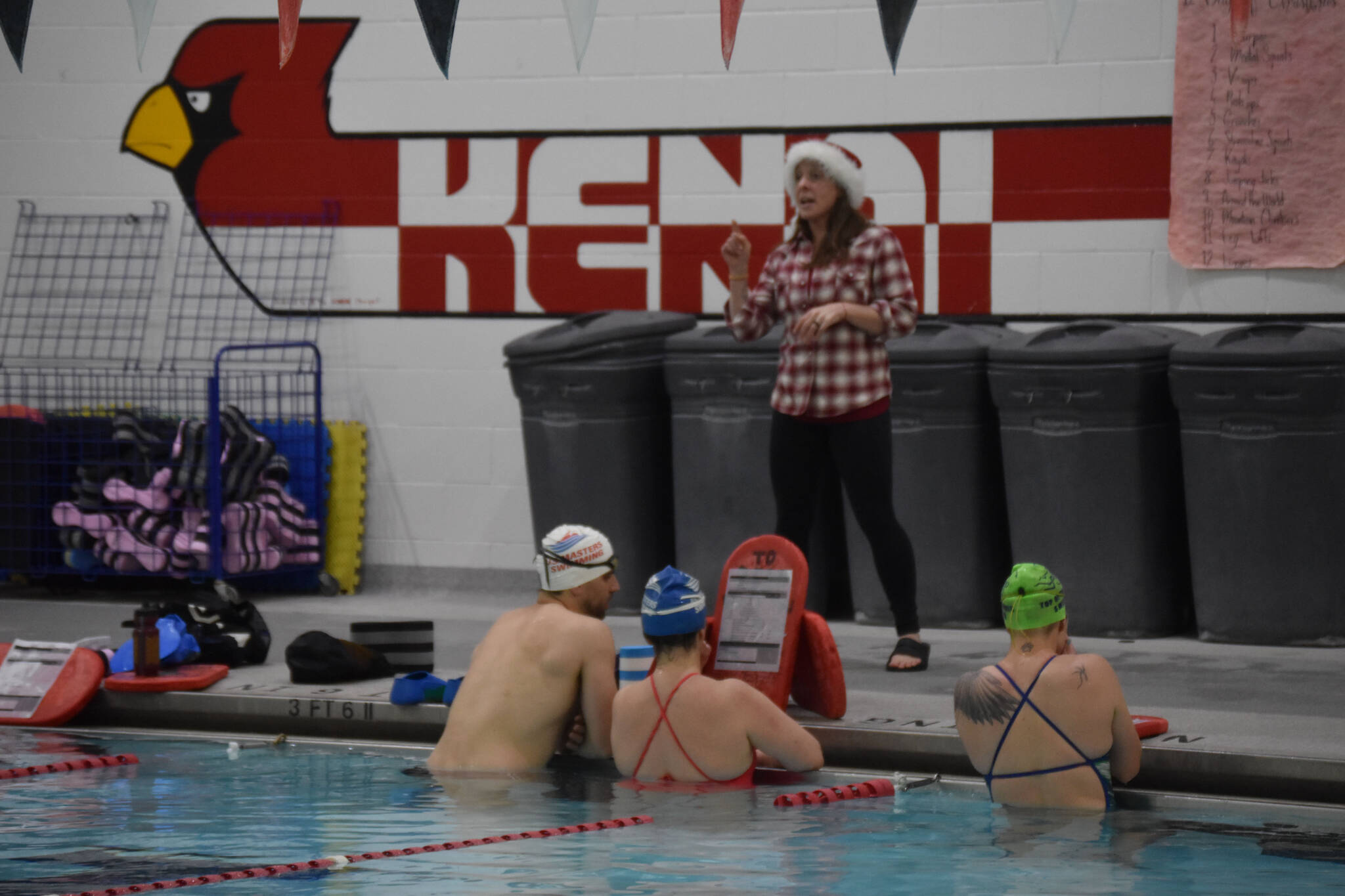 Angie Brennan directs swimmers as they prepare for a workout set during a Top of the World Swimming practice on Wednesday, Dec. 14, 2022 at Kenai Central High School in Kenai, Alaska. Brennan will be in the water instructing for Adult Learn to Swim. (Jake Dye/Peninsula Clarion)