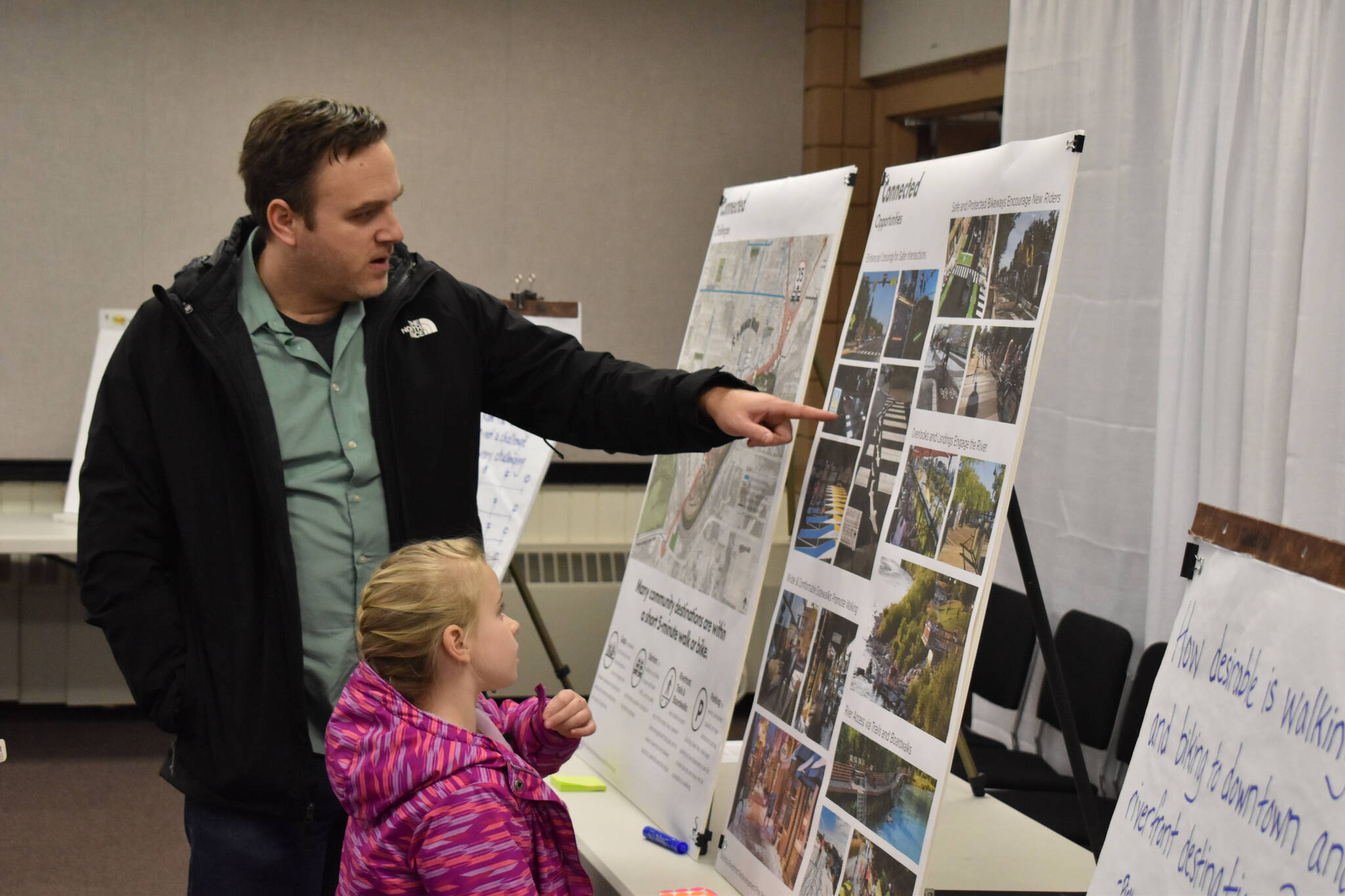 Attendees examine concept boards on Thursday, Jan. 12, 2023, at the Soldotna Riverfront Redevelopment Open House at the Soldotna Regional Sports Complex in Soldotna, Alaska. (Jake Dye/Peninsula Clarion)