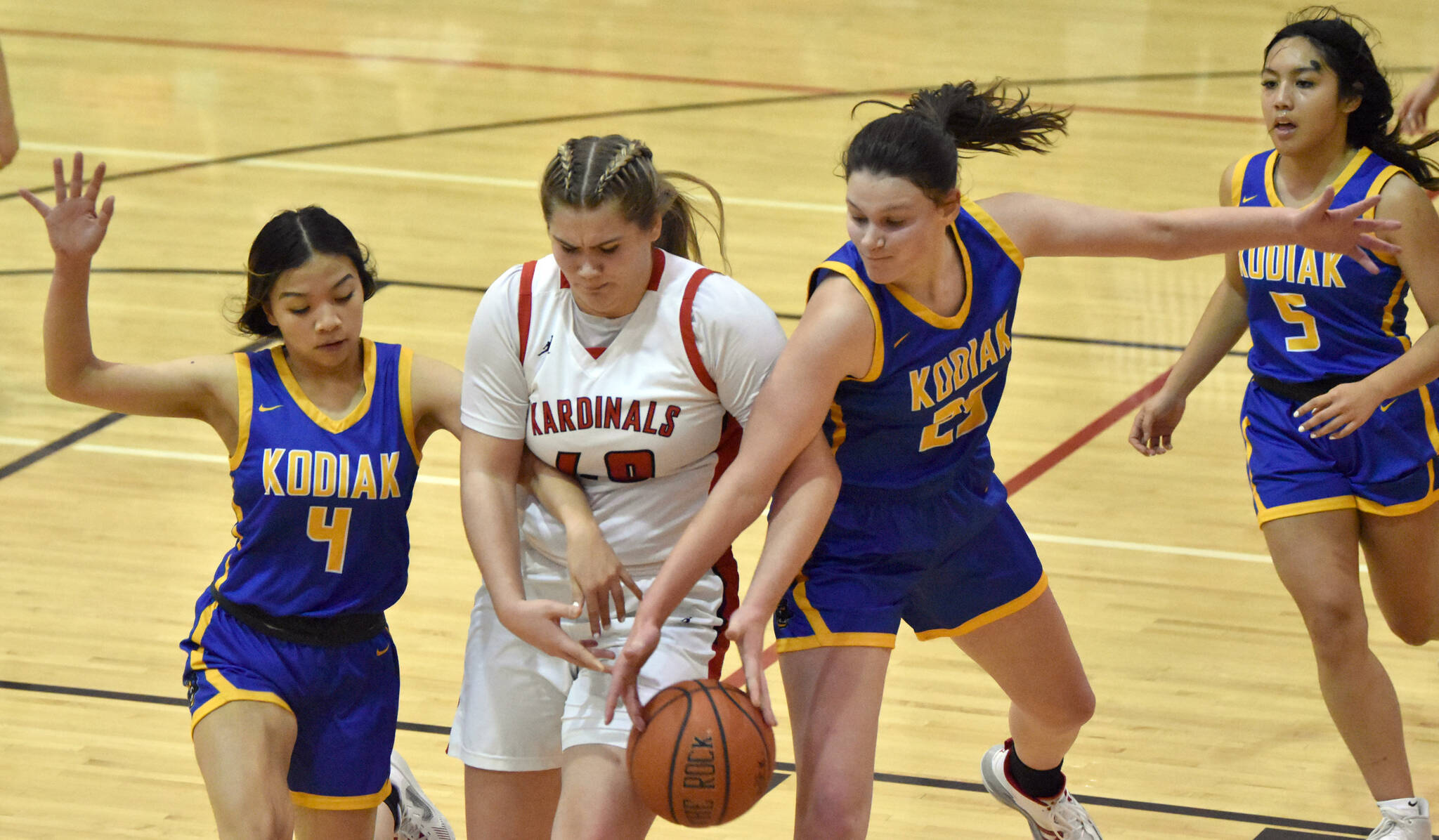Kenai Central’s Emma Beck battles Kodiak’s Lakeisha Sanchez and Angelina Enriquez for the ball Thursday, Jan. 12, 2023, at Kenai Central High School in Kenai, Alaska. (Photo by Jeff Helminiak/Peninsula Clarion)