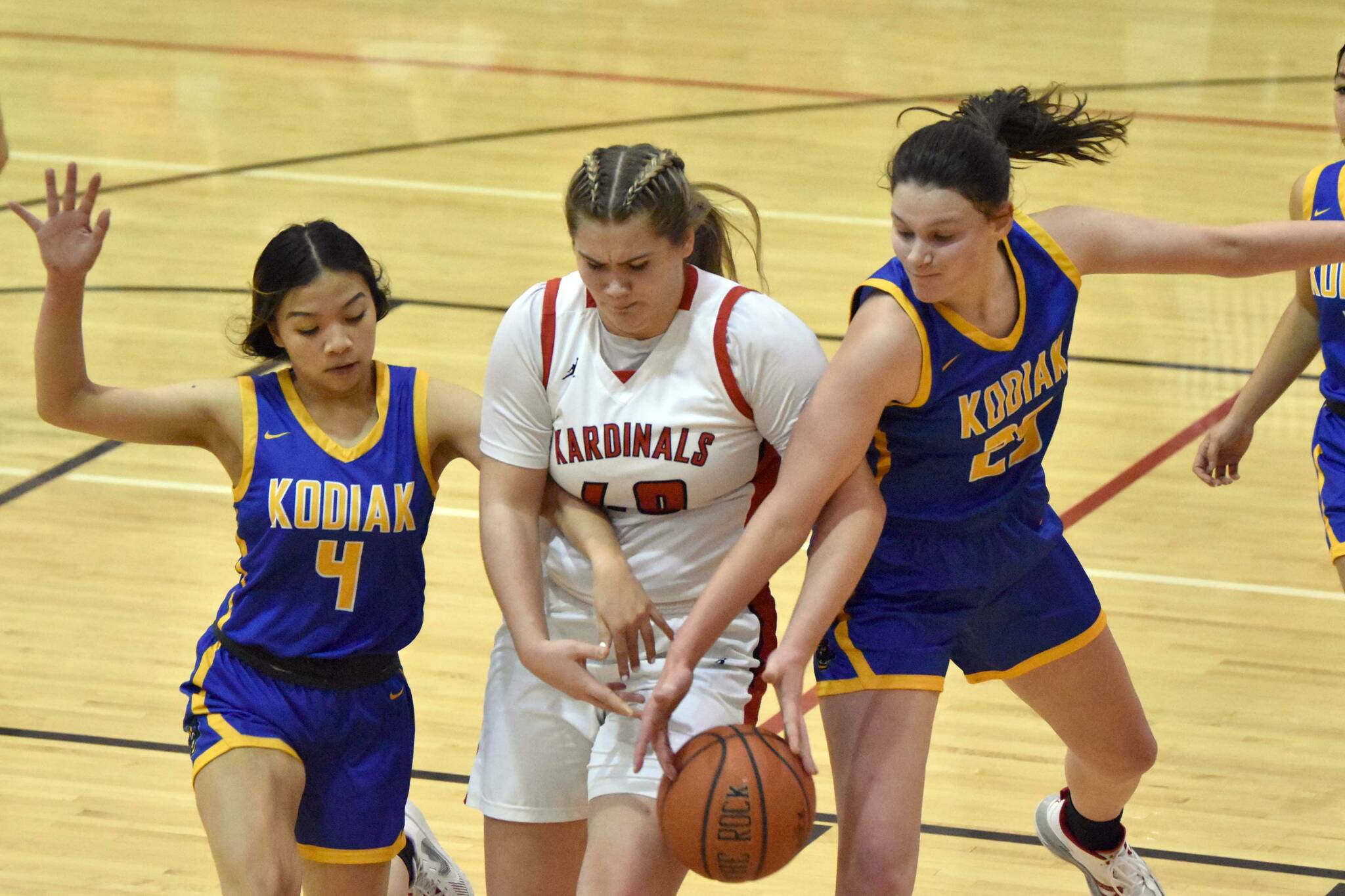 Kenai Central's Emma Beck battles Kodiak's Lakeisha Sanchez and Angelina Enriquez for the ball Thursday, Jan. 12, 2023, at Kenai Central High School in Kenai, Alaska. (Photo by Jeff Helminiak/Peninsula Clarion)