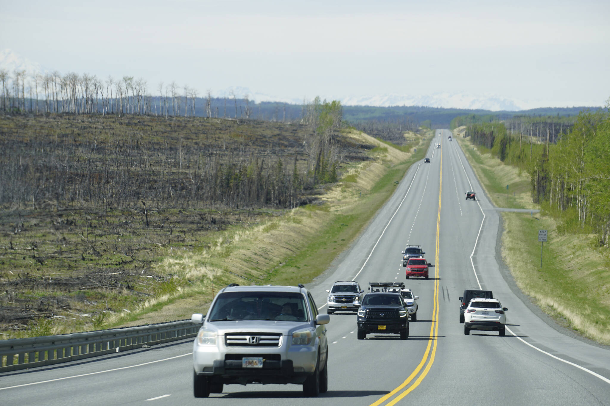 Motorists travel through the Swan Lake fire burn on the Sterling Highway on Sunday, May 22, 2022. (Photo by Michael Armstrong/Homer News)