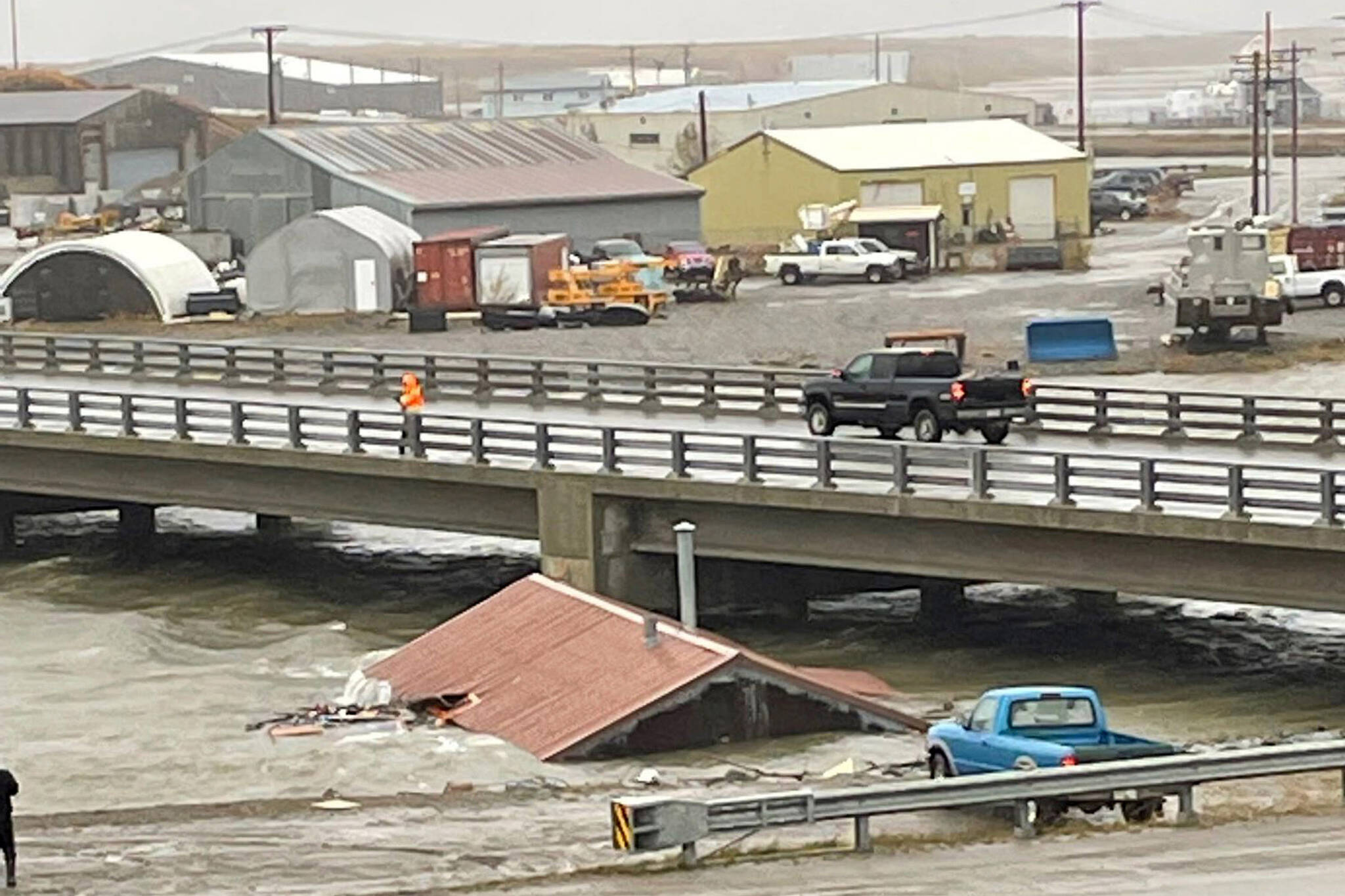 A home that was knocked off its foundation floats down Snake River during a severe storm in Nome, Alaska, is caught under a bridge on, Sept. 17, 2022. After the remnants of a rare typhoon caused extensive damage along Alaska’s western coast last fall, the U.S. government stepped in to help residents, largely Alaska Natives, recovery financially. (AP Photo/Peggy Fagerstrom, File)