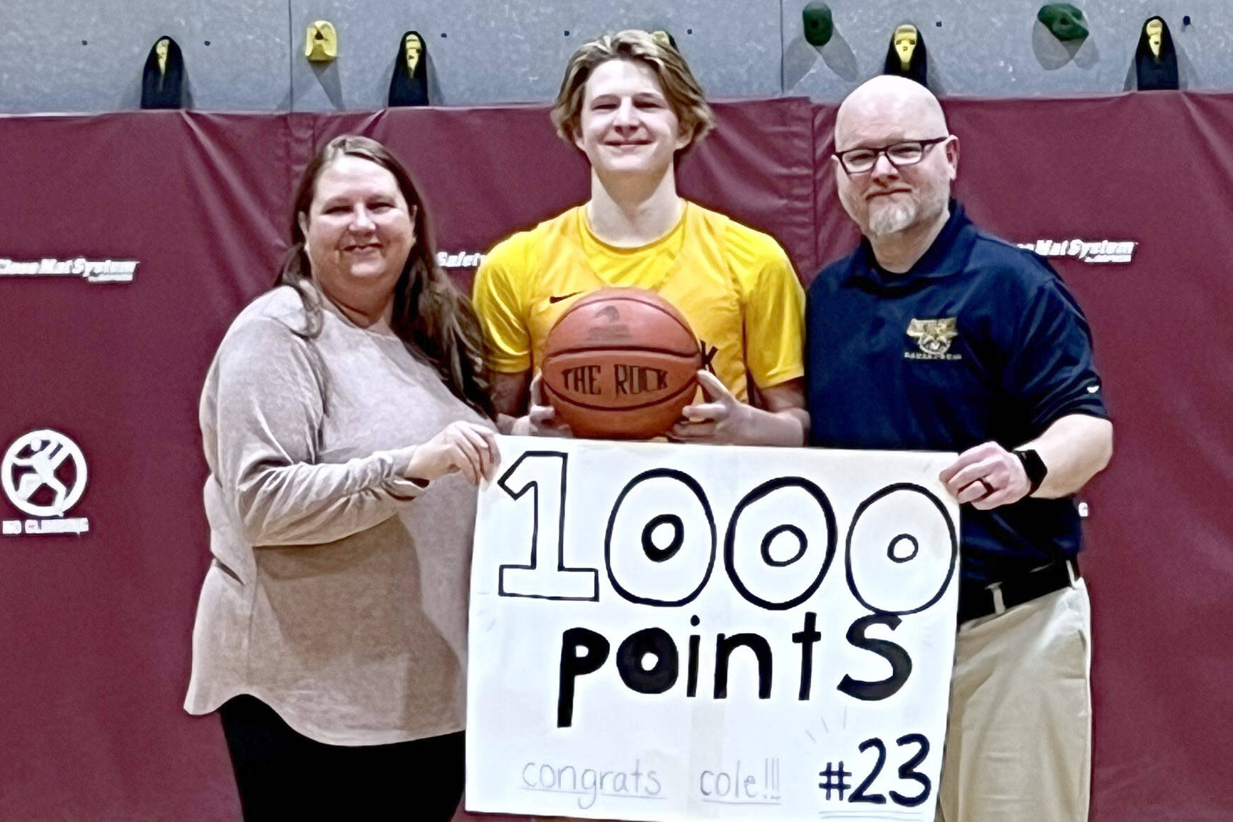 Ninilchik's Colvin Moore, with parents Robin and Brian Moore, scored his 1,000th high school point Saturday, Jan. 14, 2022, at Tok, Alaska. (Photo provided)