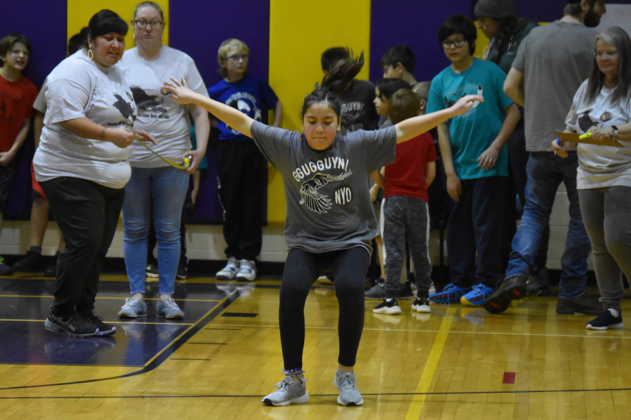 An athlete competing for the Kenaitze Indian Tribe in the Junior division sticks her landing while performing the scissor broad jump during the Kahtnuht’ana Hey Chi’ula NYO Invitational on Frdiay, Jan. 13, 2023, at Kenai Middle School in Kenai, Alaska. (Jake Dye/Peninsula Clarion)