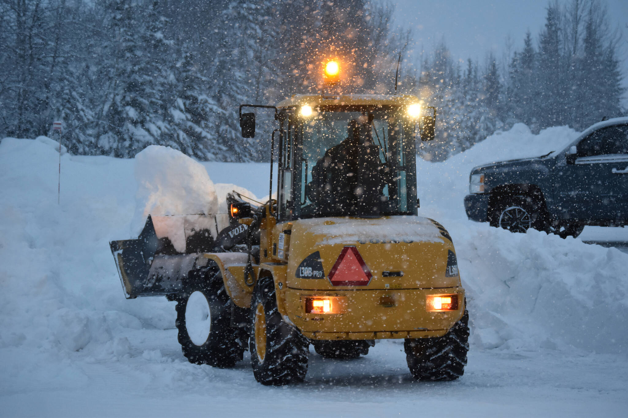 Snow is cleared from the road during the start of another major snowfall on Wednesday, Dec. 14, 2022, outside the Peninsula Clarion offices in Kenai, Alaska. (Jake Dye/Peninsula Clarion)