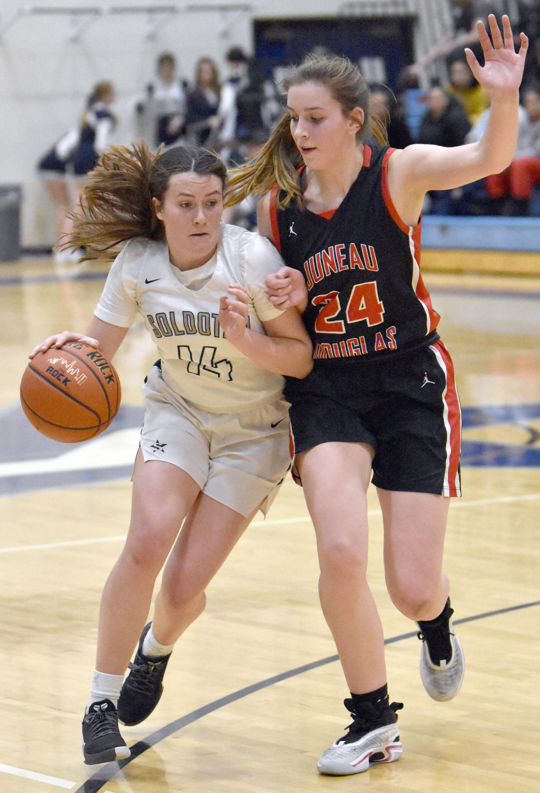 Soldotna’s Tanner Inman drives on Mila Hargrave of Juneau-Douglas on Thursday, Jan. 26, 2023, at the Al Howard Tournament at Soldotna High School in Soldotna, Alaska. (Photo by Jeff Helminiak/Peninsula Clarion)