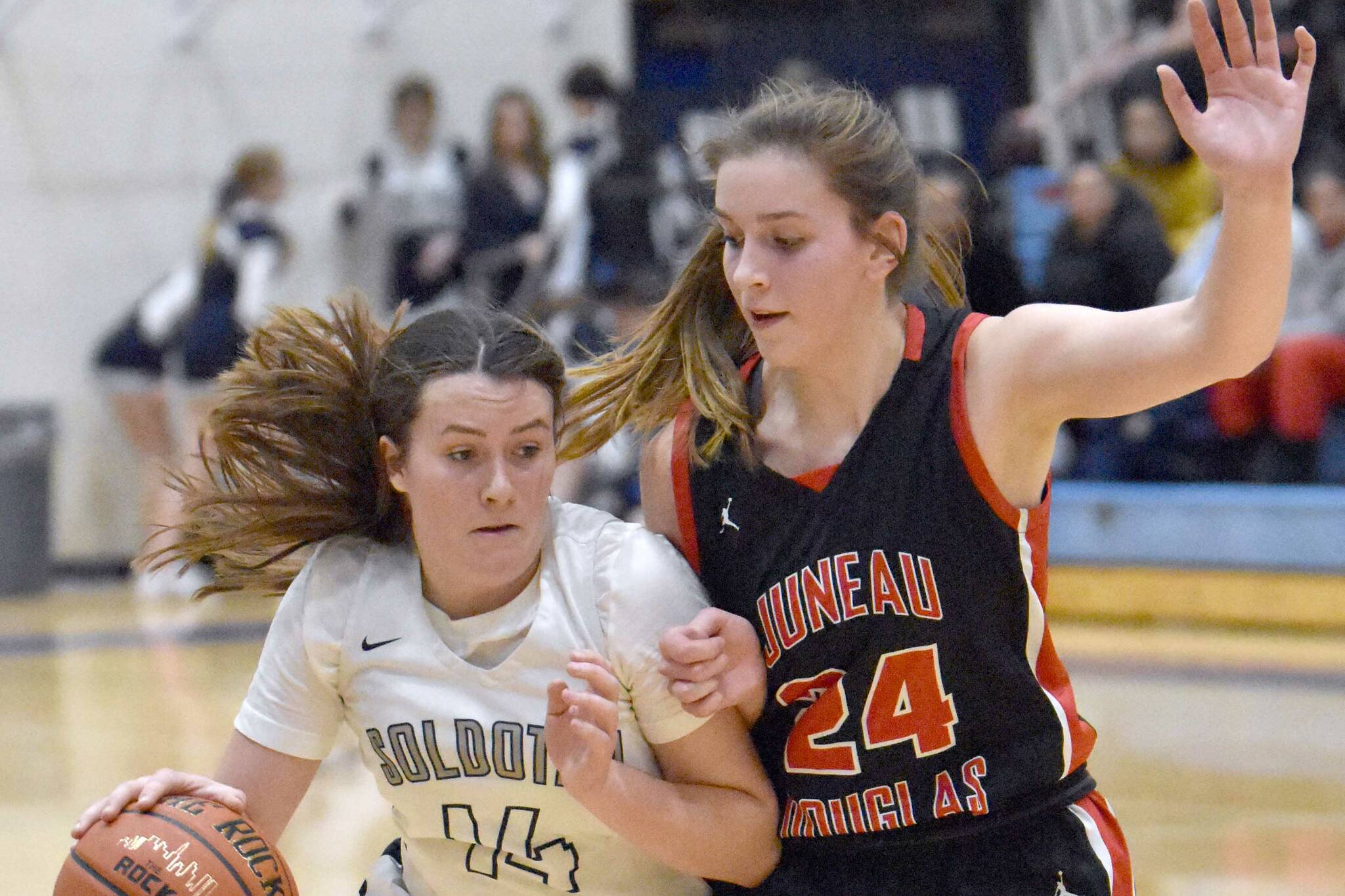 Soldotna's Tanner Inman drives on Mila Hargrave of Juneau-Douglas on Thursday, Jan. 26, 2023, at the Al Howard Tournament at Soldotna High School in Soldotna, Alaska. (Photo by Jeff Helminiak/Peninsula Clarion)