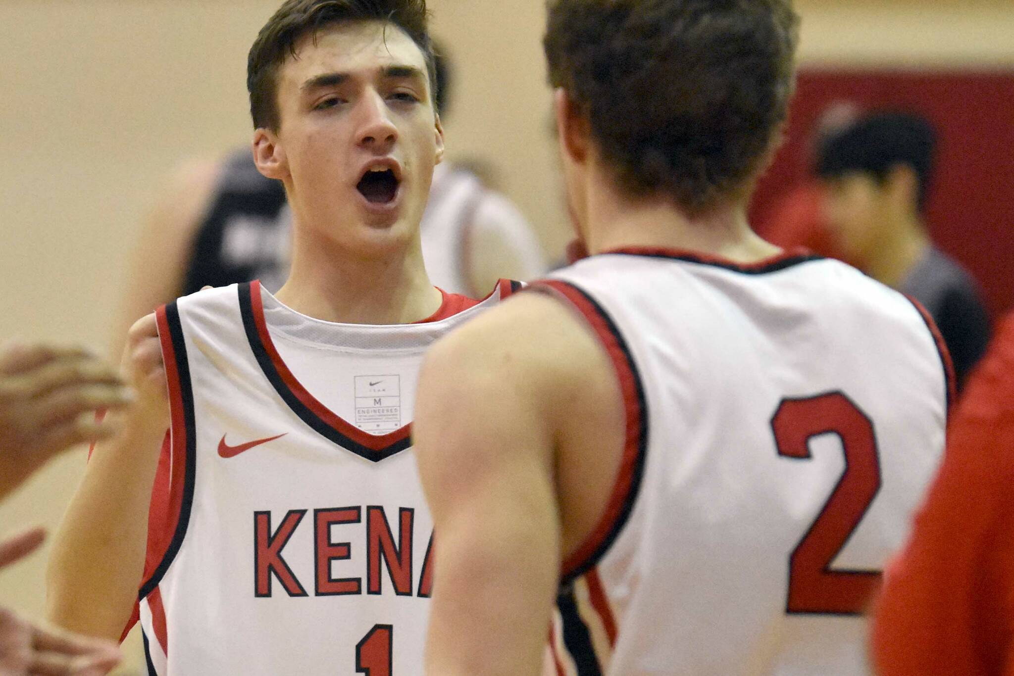 Kenai Central senior Owen Whicker holds up Zach Armstrong's jersey as Zach's brother, Luke, runs out during pregame introductions. Zach was diagnosed with leukemia in November. The Tuesday, Jan. 31, 2023, game against Nikiski at Kenai Central High School in Kenai, Alaska, was a fundraiser for the Armstrong family. (Photo by Jeff Helminiak/Peninsula Clarion)