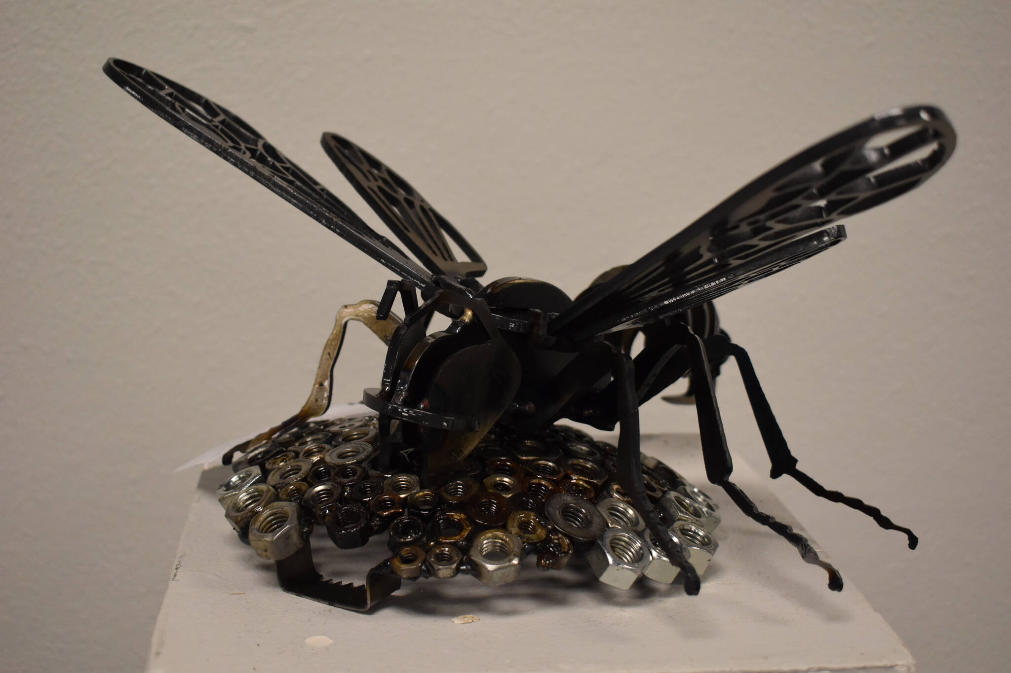 A bee crafted of metal sits atop a honeycomb of hexnuts on Tuesday, Jan. 31, 2023, at the Kenai Art Center, in Kenai, Alaska, as part of Metalwork & Play. (Jake Dye/Peninsula Clarion)