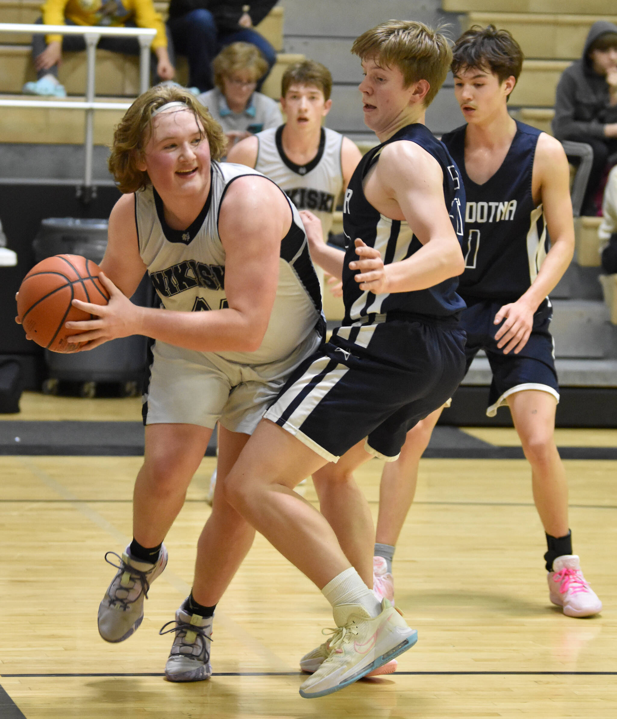 Nikiski’s Charlie Chamberlain drives on Soldotna’s Andrew Pieh on Tuesday, Feb. 7, 2023, at Nikiski High School in Nikiski, Alaska. (Photo by Jeff Helminiak/Peninsula Clarion)