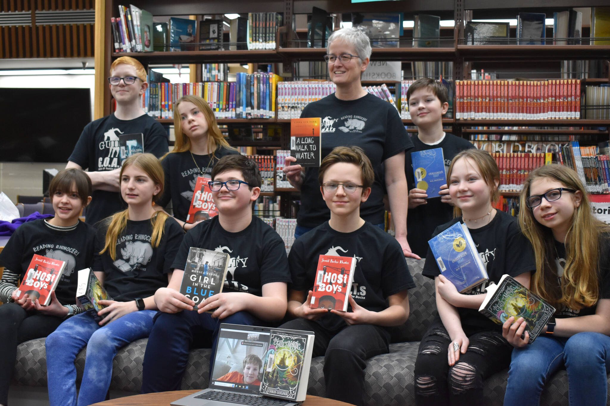 Kenai Middle School Battle of the Books teams, the Reading Rhinoceri and the Guilty GOATs, gather for a photo after their first match during Kenai Peninsula Borough School District Middle School Battle of the Books competition on Thursday, Feb. 9, 2023, at Kenai Middle School in Kenai, Alaska. (Jake Dye/Peninsula Clarion)