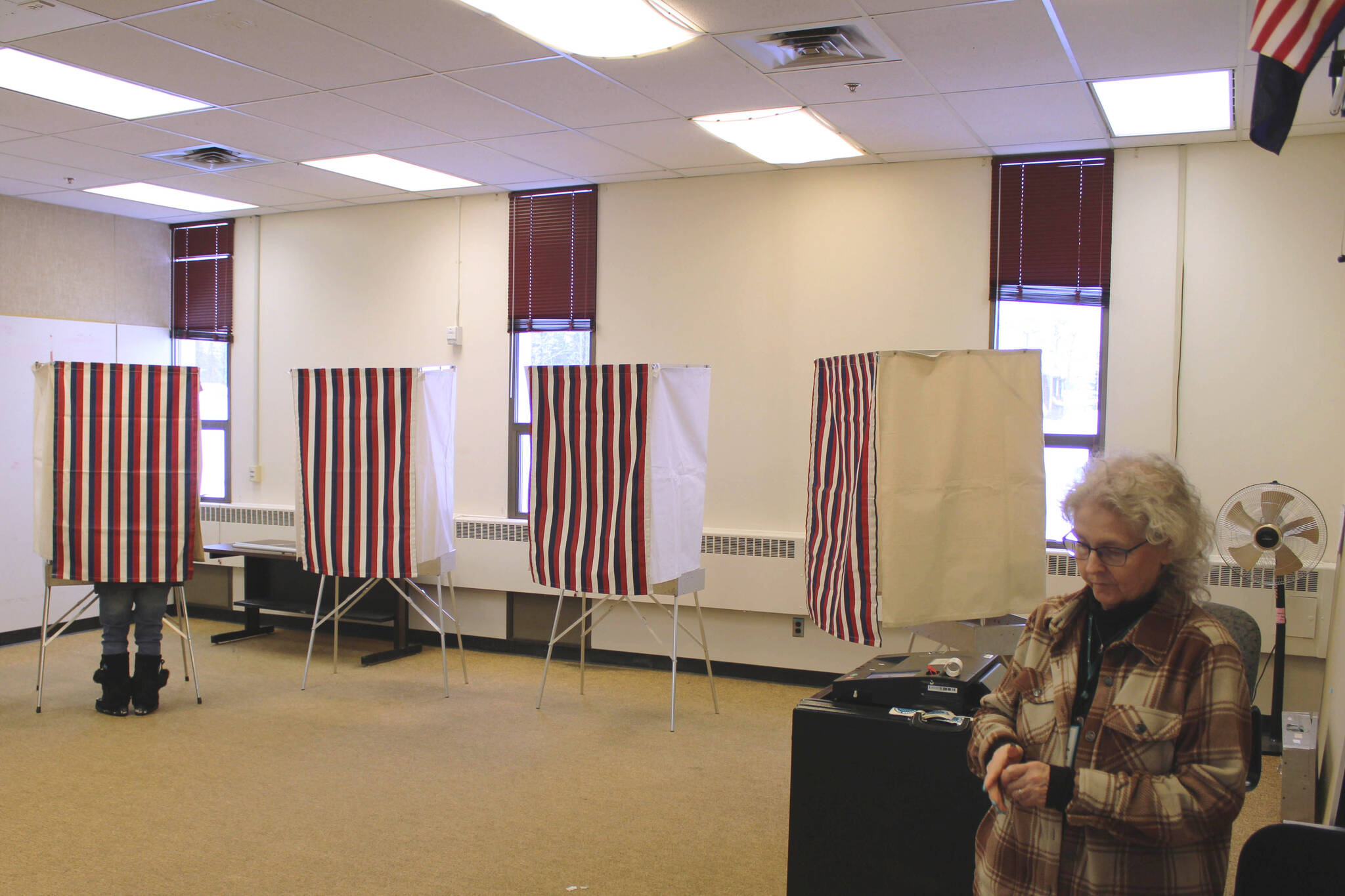 Teresa Minnich, right, waits to help voters feed their ballot into a tabulation machine at Soldotna Prep School on Tuesday, Feb. 14, 2023, in Soldotna, Alaska. (Ashlyn O’Hara/Peninsula Clarion)
