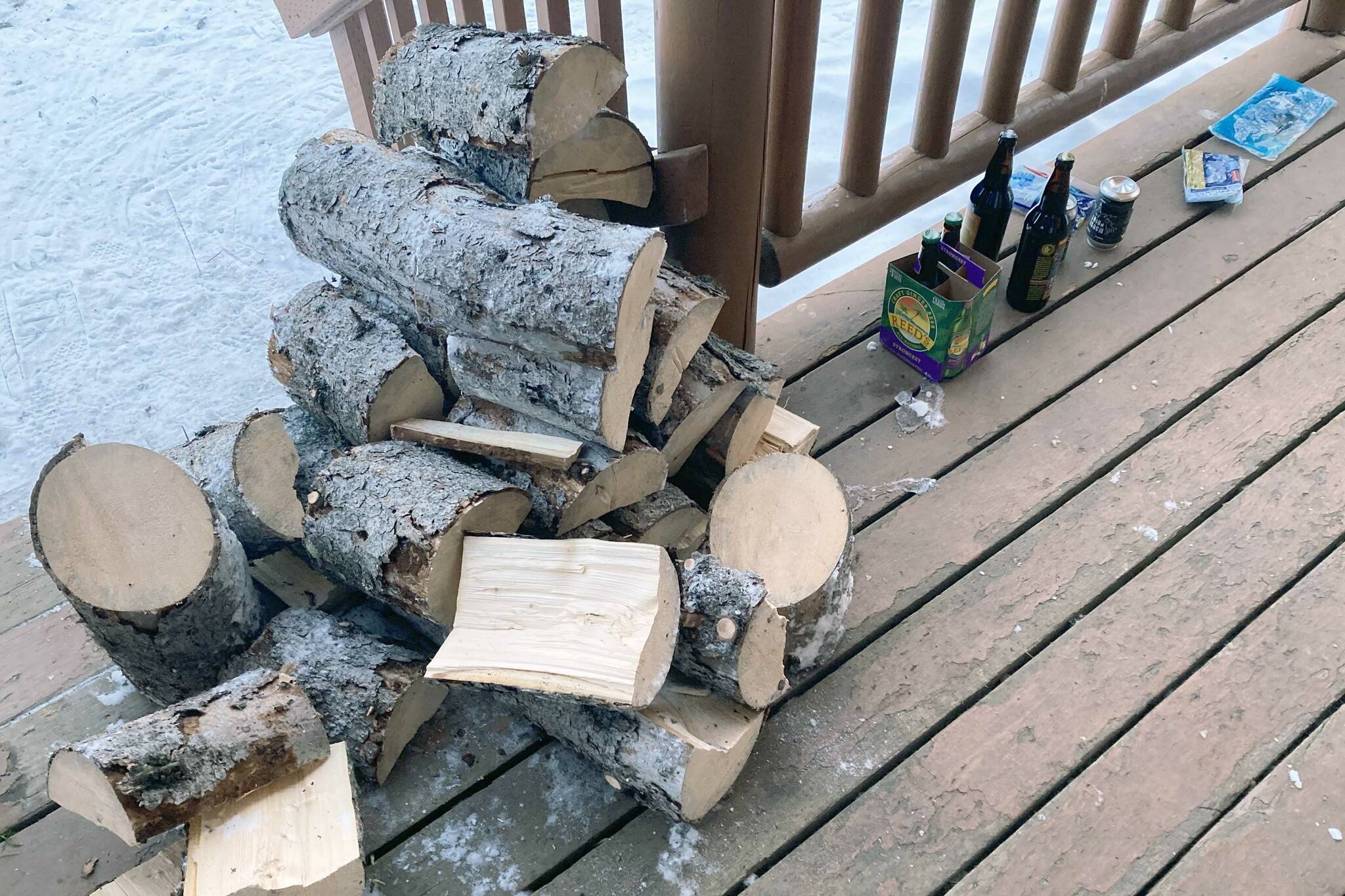 Split spruce for firewood sits on the porch of the Dolly Varden Lake cabin on Feb. 5, 2023, in the Kenai National Wildlife Refuge in Alaska. (Photo by Jeff Helminiak/Peninsula Clarion)