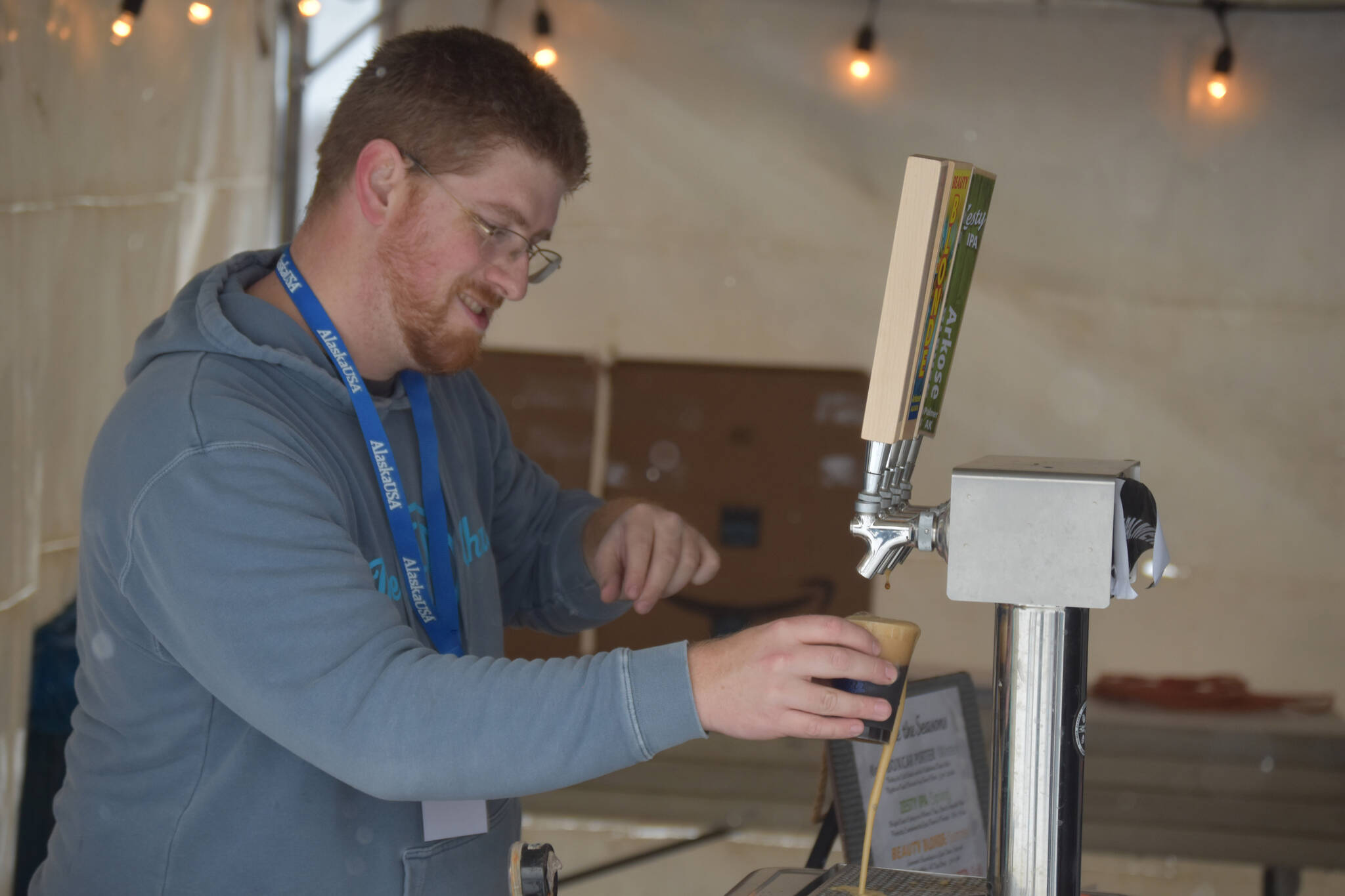 A brewer from Arkose Brewery fills a tasting cup during Frozen RiverFest on Saturday, Feb. 18, 2023 at Soldotna Creek Park in Soldotna, Alaska. (Jake Dye/Peninsula Clarion)
