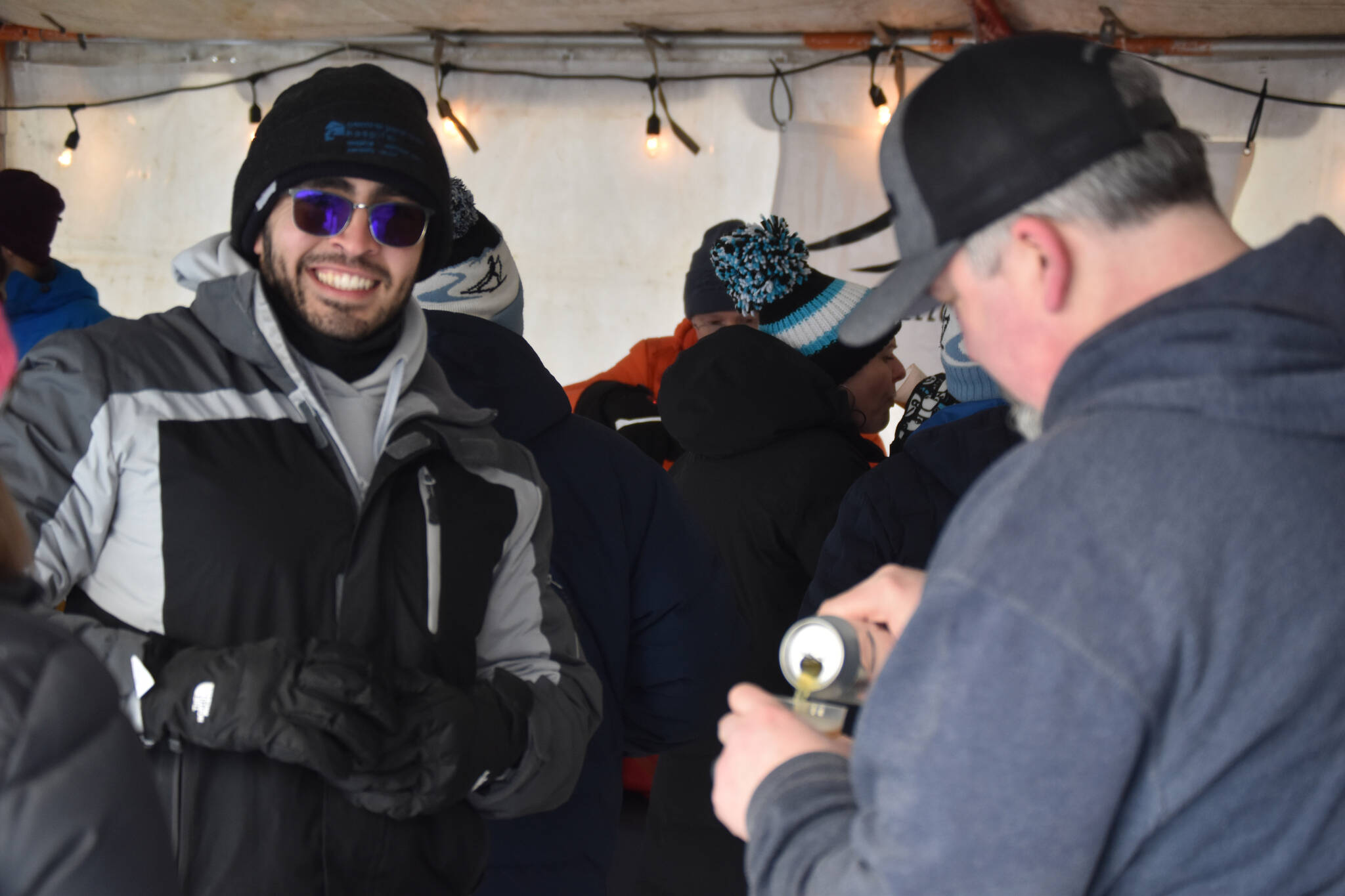 An attendee gets a drink from HooDoo Brewing Company during Frozen RiverFest on Saturday, Feb. 18, 2023 at Soldotna Creek Park in Soldotna, Alaska. (Jake Dye/Peninsula Clarion)