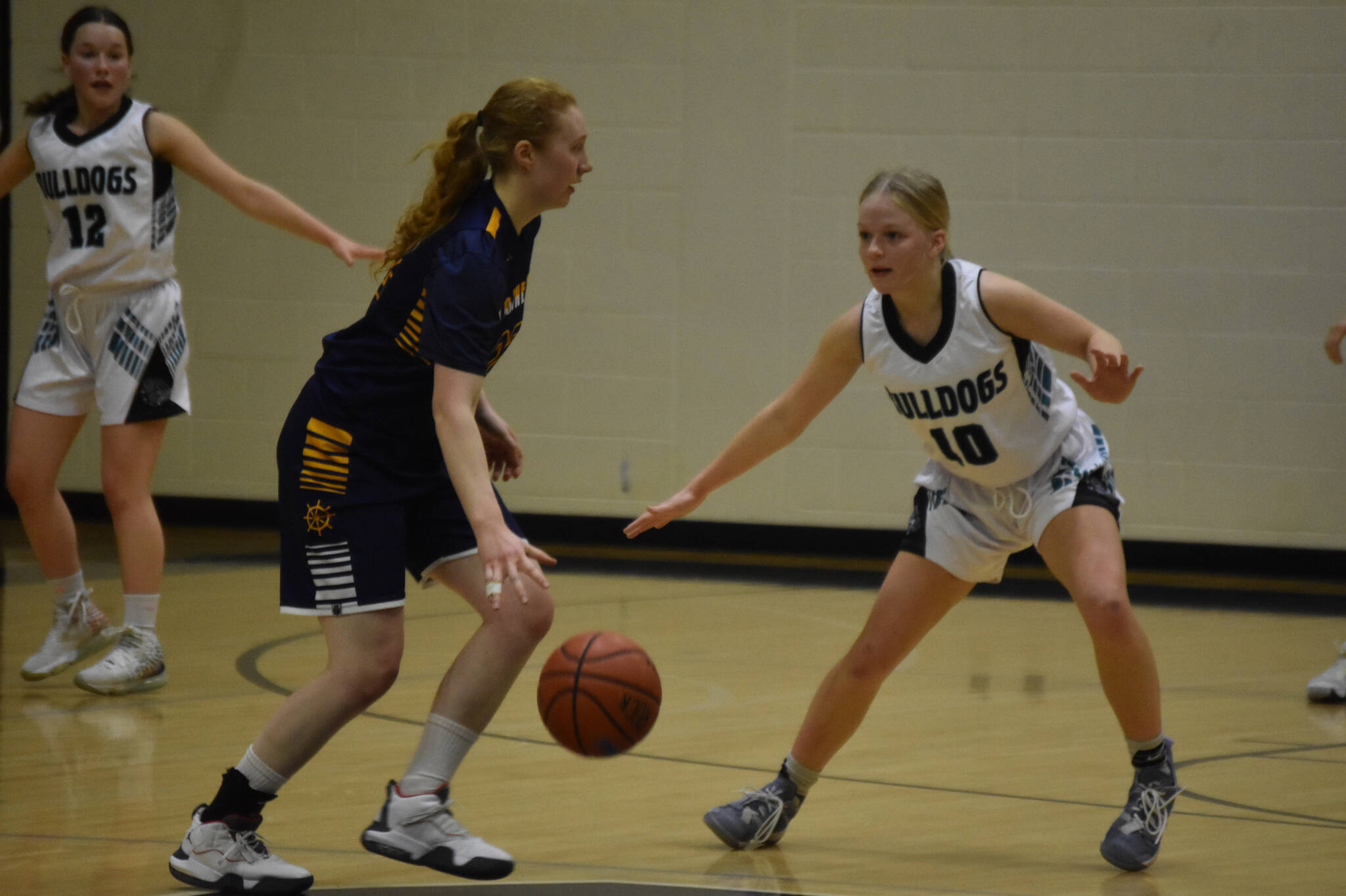 Homer's Lawson Alexson dribbles the ball while Nikiski's Avery White moves to defend during a basketball game on Tuesday Feb. 21, 2023, at Nikiski Middle/High School in Nikiski, Alaska. (Jake Dye/Peninsula Clarion)