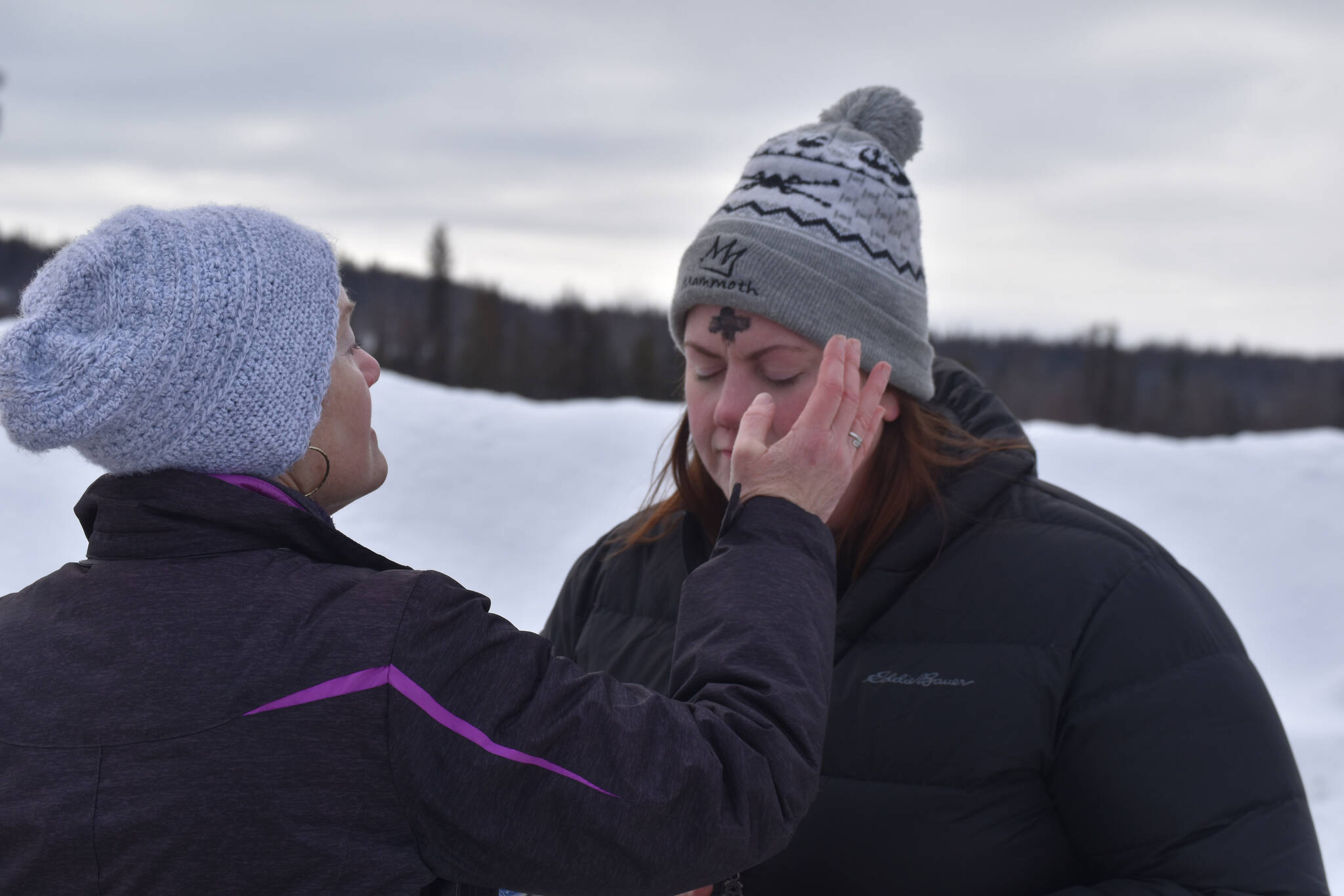 Pastor Karen Martin Tichenor applies ashes to Pastor Meredith Harber’s forehead as they prepare for Ashes to Go! on Wednesday; Feb. 22; 2023 at Soldotna Creek Park in Soldotna; Alaska. (Jake Dye/Peninsula Clarion)