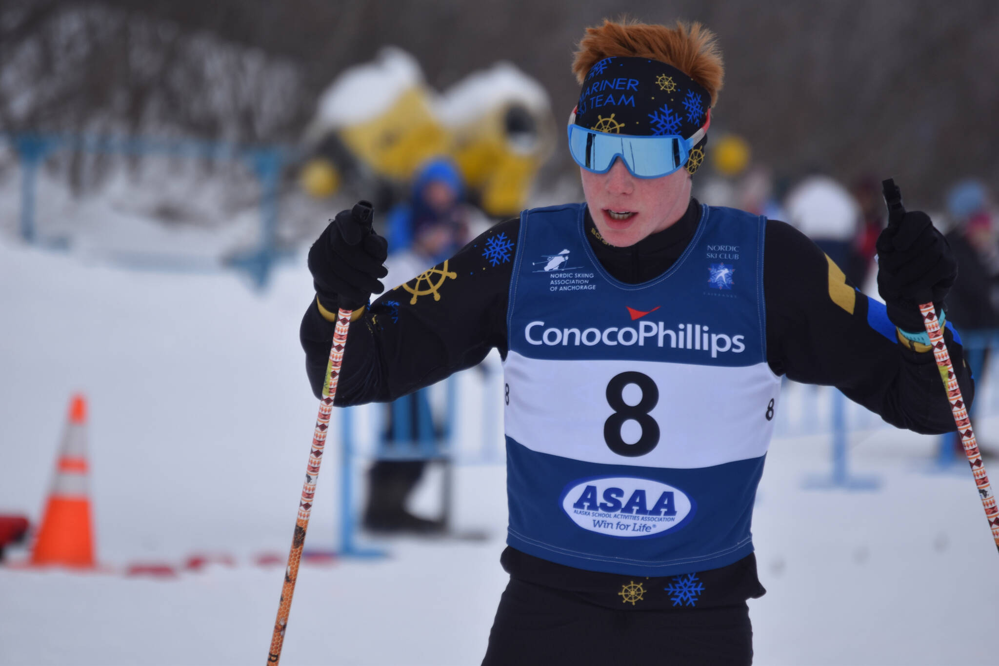 Jody Goodrich puts his sticks down in the snow as he slows to a stop in the finish chute after the final leg of the boys 4x5-kilometer relay at the ASAA State Nordic Ski Championships at Kincaid Park in Anchorage, Alaska, on Saturday, Feb. 25, 2023. (Jake Dye/Peninsula Clarion)