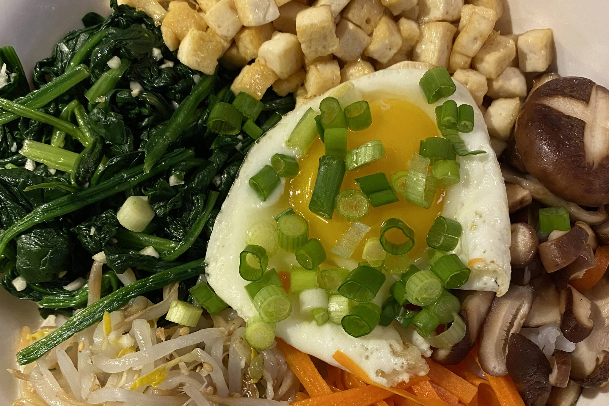 Tofu, spinach, fried egg, carrots, mushrooms and sprouts are served on rice in this Korean Bibimbap recipe. (Photo by Tressa Dale/Peninsula Clarion)