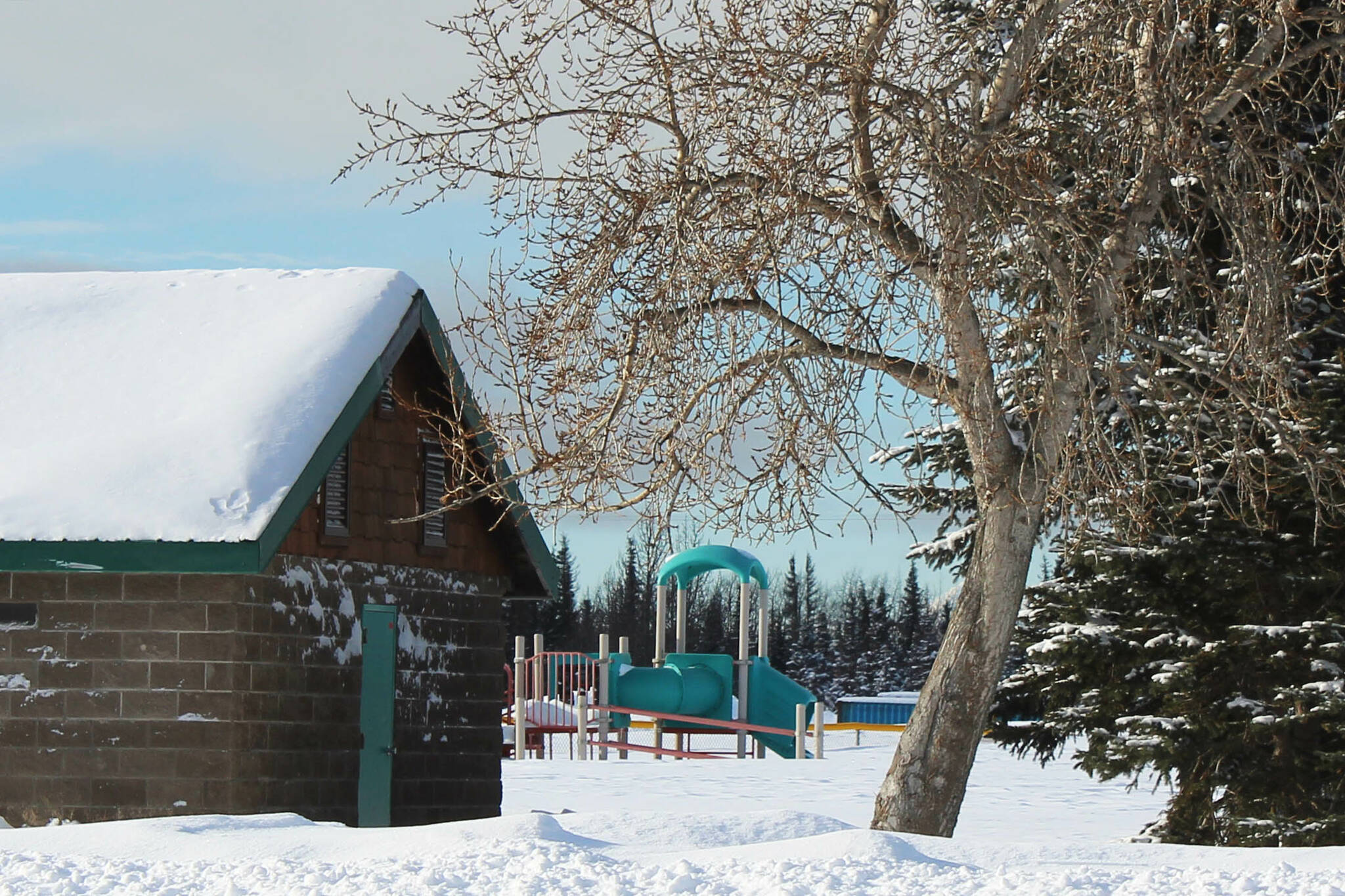 Snow surrounds playground equipment at the softball greenstrip on Wednesday, March 1, 2023 in Kenai, Alaska. The structure is being replaced this year. (Ashlyn O'Hara/Peninsula Clarion)