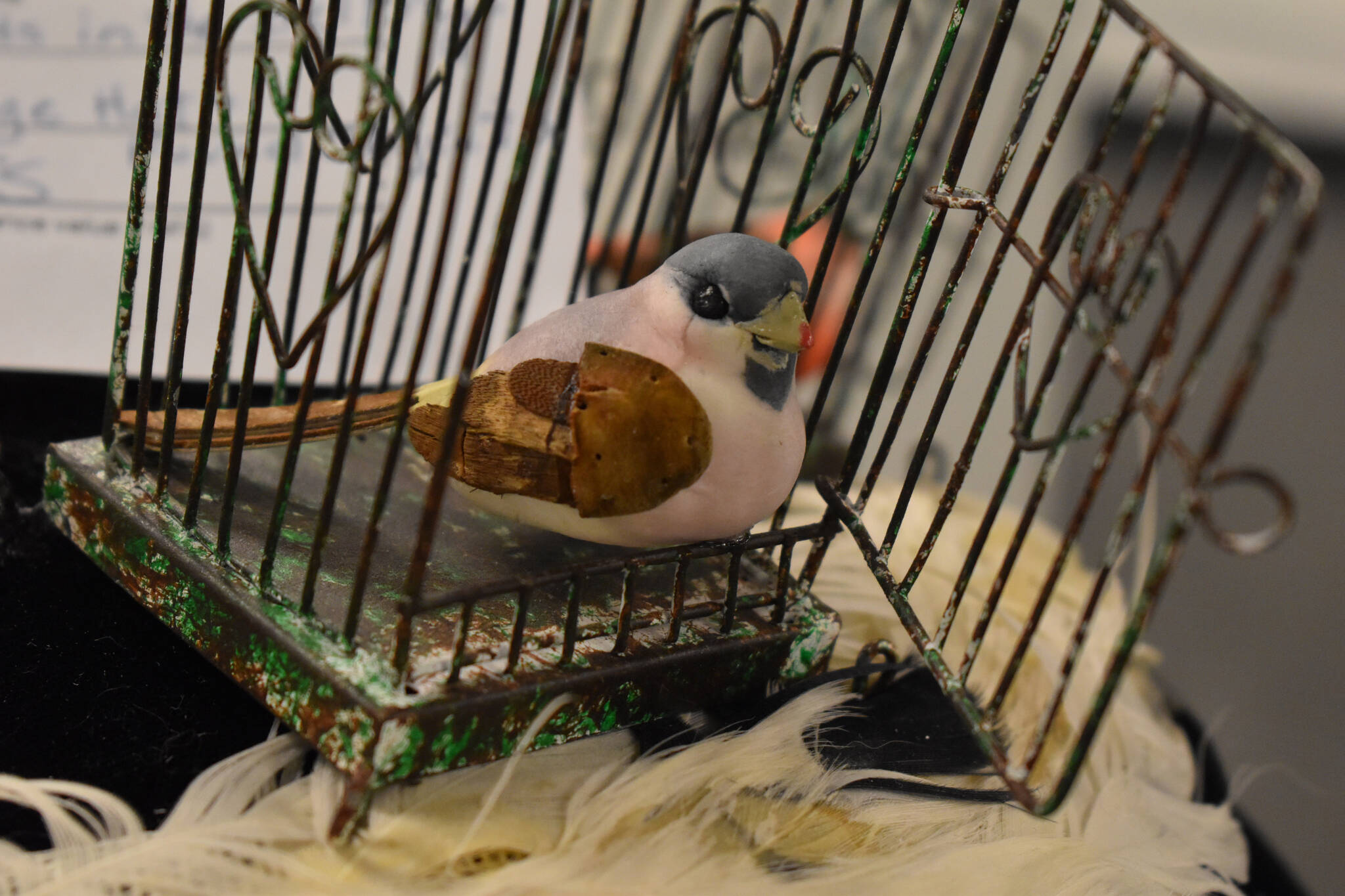 A small sculpture of a bird in a cage rests in a nest at the Kenai Art Center in Kenai, Alaska, on Tuesday, Feb. 28, 2023. (Jake Dye/Peninsula Clarion)