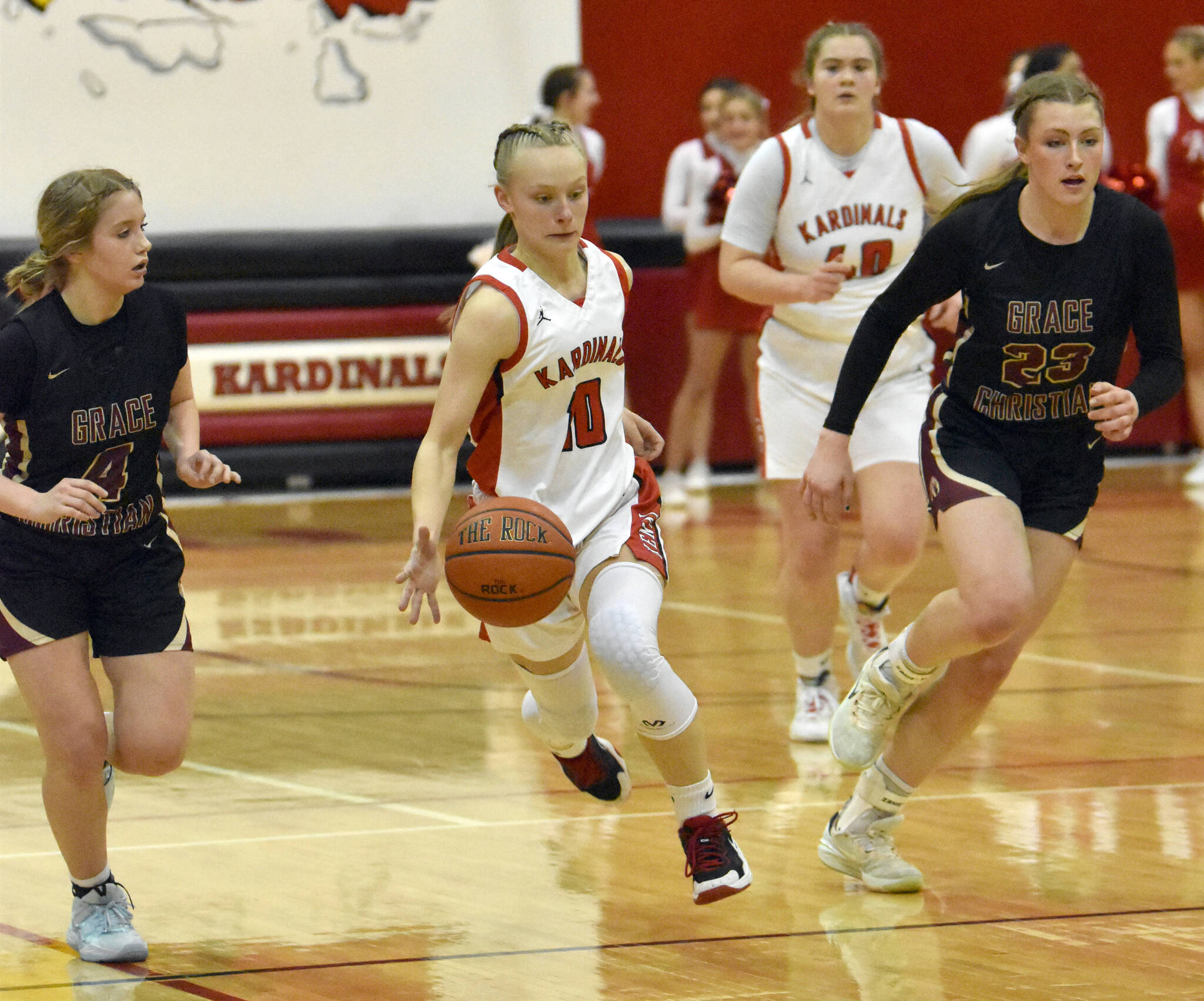 Kenai Central’s Rylie Sparks splits Grace Christian’s Poppy Wiggers-Pidduck and Sophie Lentfer on Friday, March 3, 2023, at Kenai Central High School in Kenai, Alaska. (Photo by Jeff Helminiak/Peninsula Clarion)