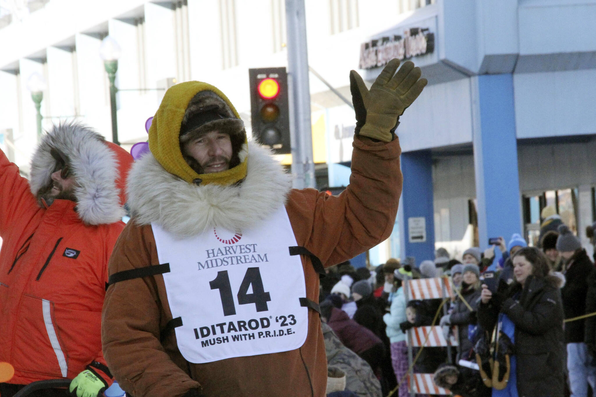 Defending champion Brent Sass, wearing bib No. 14, waves to the crowd during the Iditarod Trail Sled Dog Race’s ceremonial start in downtown Anchorage, Alaska, on Saturday, March 4, 2023. Sass withdrew from this year’s race, Saturday, March 11, 2023, citing concerns for his health. (AP Photo/Mark Thiessen, File)