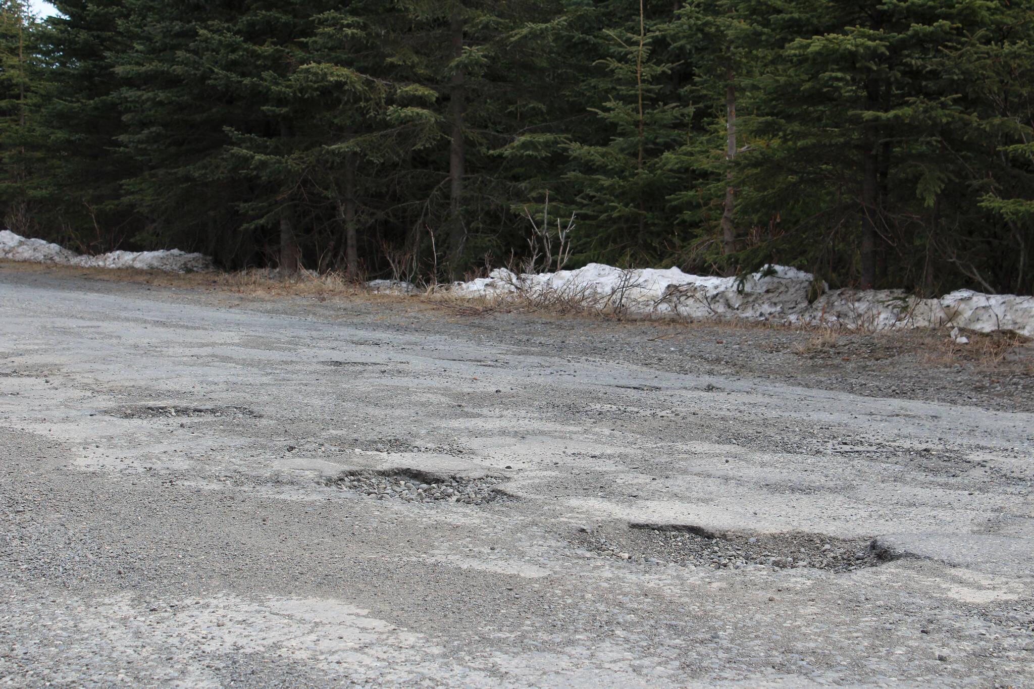 Potholes are seen on Wildwood Drive on Thursday, April 22, 2021, in Kenai, Alaska. (Ashlyn O’Hara/Peninsula Clarion)