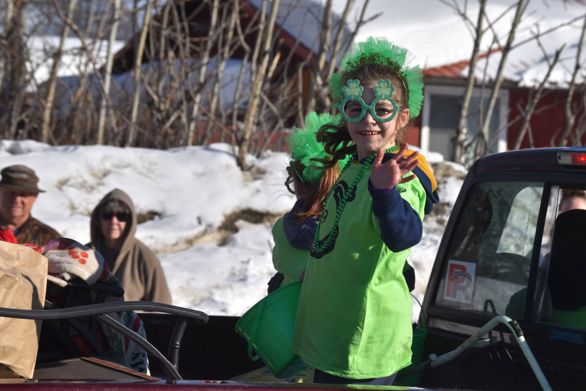 A child waves from the back of a truck as the 32nd annual Sweeney’s St. Patrick’s Day Parade proceeds down Fireweed Street in Soldotna, Alaska on Friday, March 17, 2023. (Jake Dye/Peninsula Clarion)