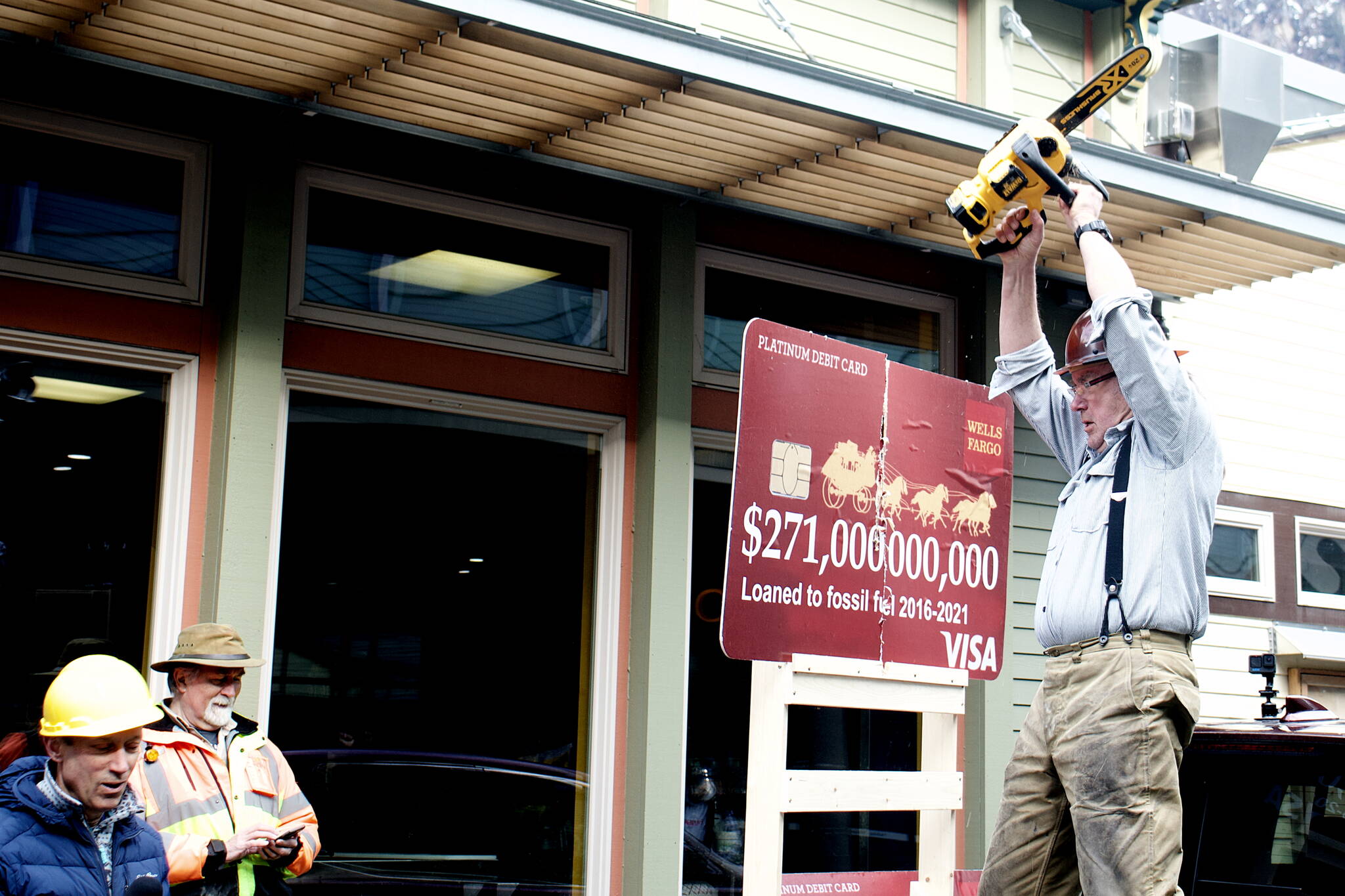 Mark Sabbatini / Juneau Empire
Bob Schroeder takes an electric chainsaw to a mock credit card during a protest outside the Wells Fargo in downtown Juneau at midday Tuesday. Schroeder cut up three mock credit cards representing three banks in Juneau protesters say are leading funders of fossil fuel development projects.