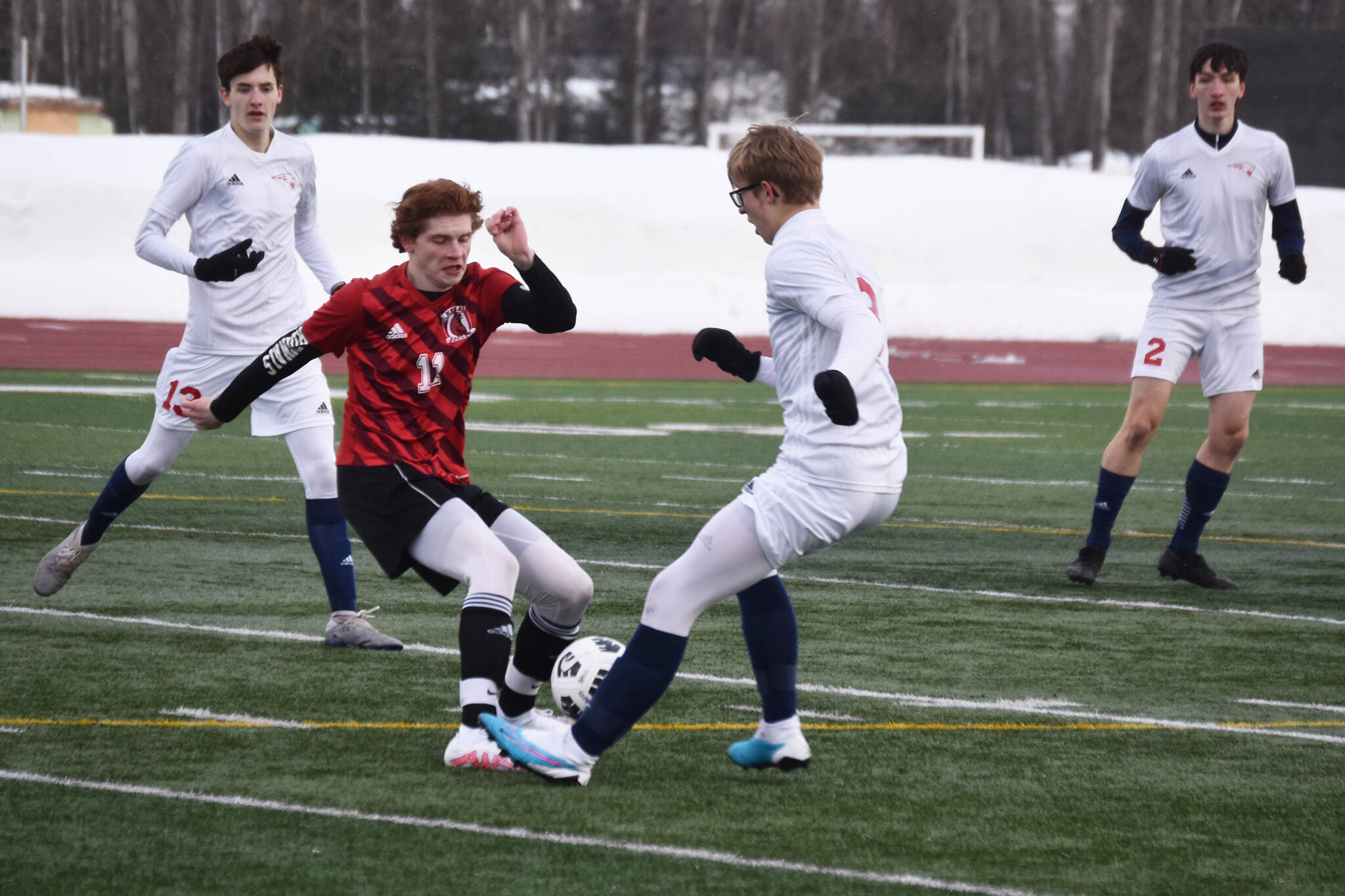 Kenai Central’s Wade James battles for the ball during a soccer game at Ed Hollier Field in Kenai, Alaska, on Thursday, March 30, 2023. (Jake Dye/Peninsula Clarion)