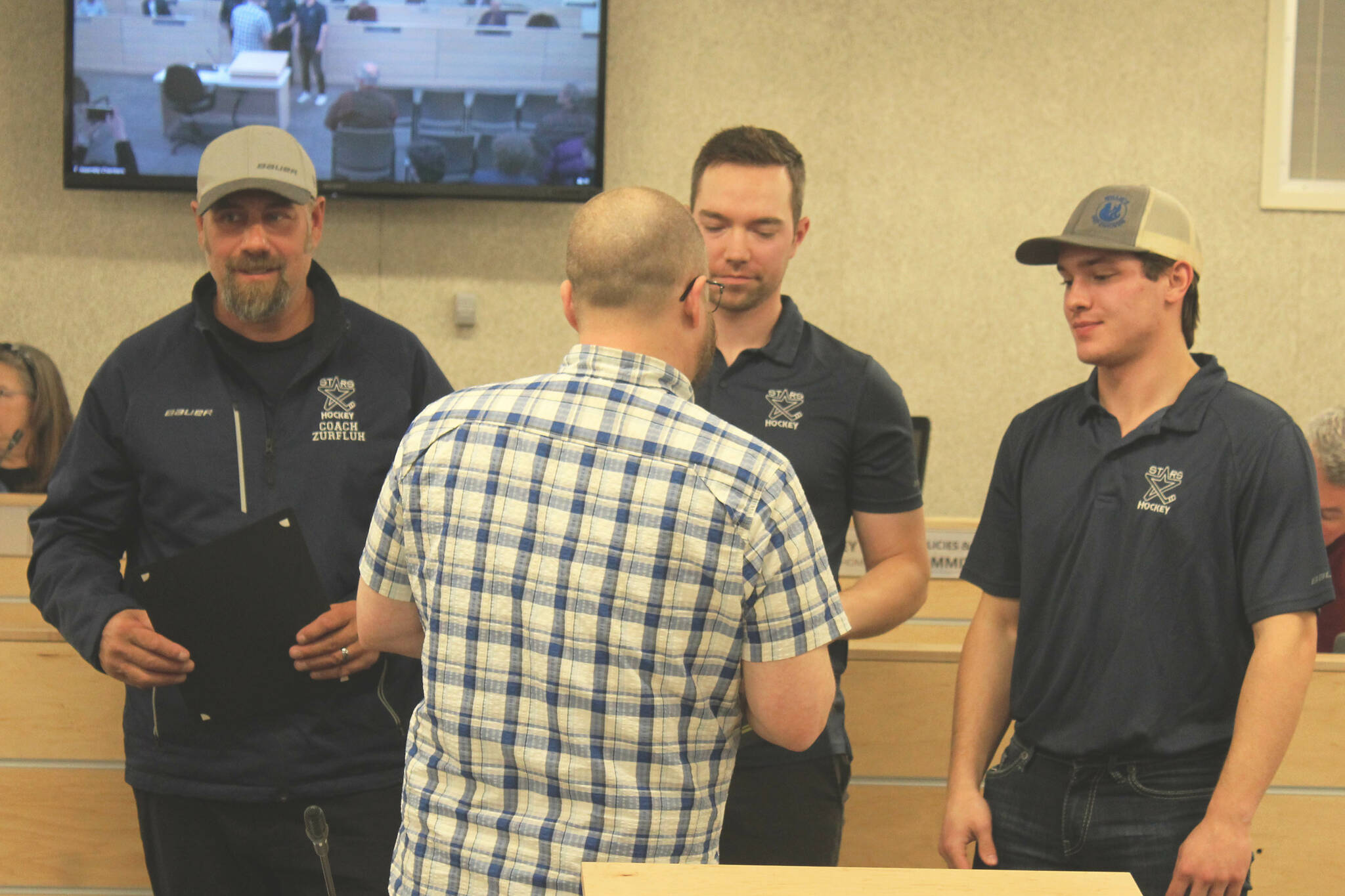 Kenai Peninsula Borough Assembly member Tyson Cox (center) presents certificates of achievement to the coaches of Soldotna High School’s hockey team during an assembly meeting on Tuesday, April 4, 2023, in Soldotna, Alaska. (Ashlyn O’Hara/Peninsula Clarion)