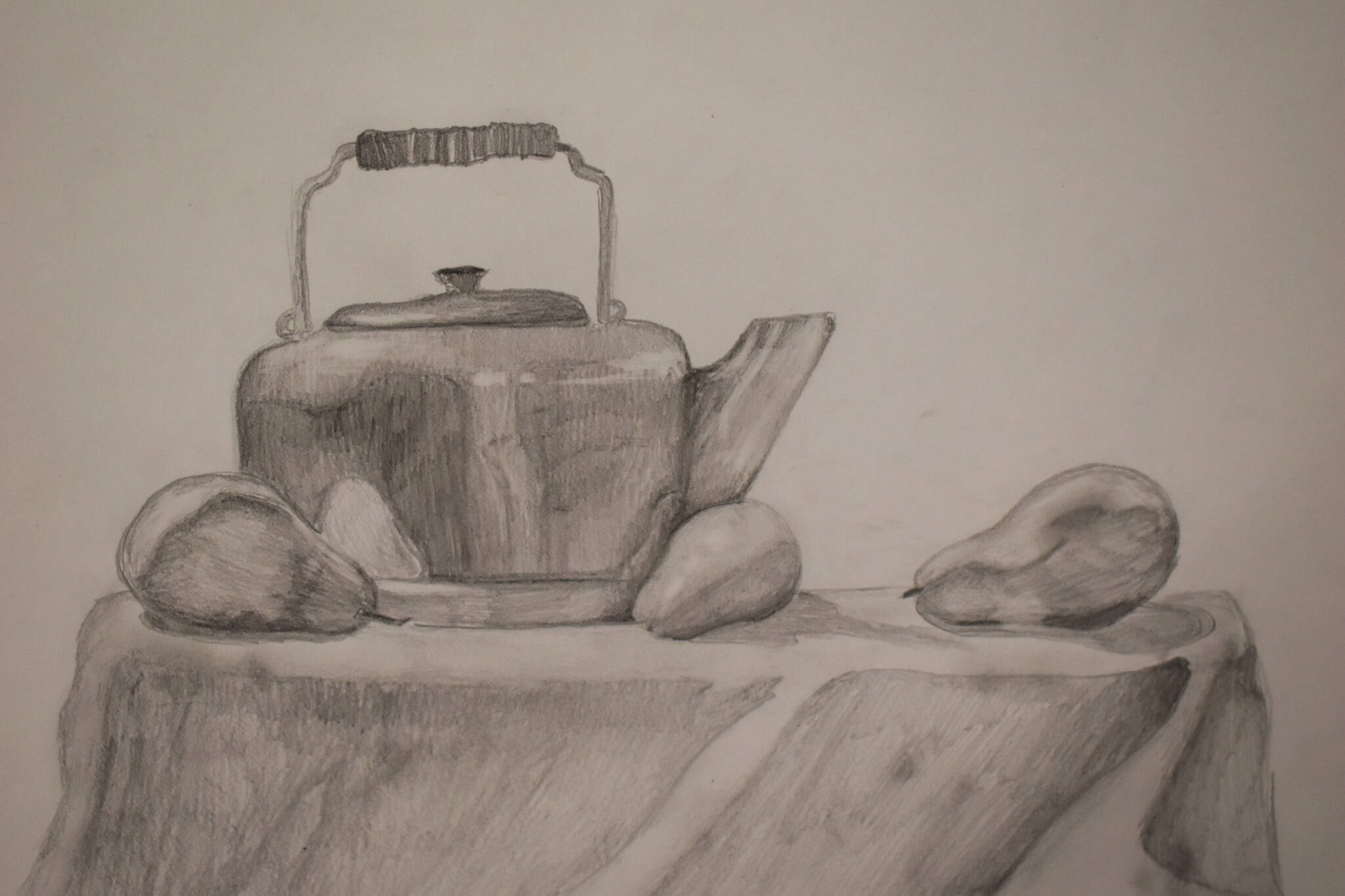 A drawing of a kettle and some pears hangs at the Kenai Art Center in Kenai, Alaska on Wednesday, April 5, 2023, in preparation for the debut of the 32nd Annual Kenai Peninsula Borough School District Visual Feast. (Jake Dye/Peninsula Clarion)