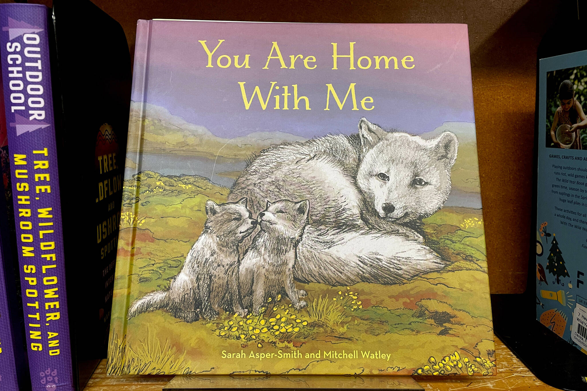 The children’s book “You Are Home With Me,” illustrated by Mitchell Thomas Watley, is shown at a bookstore in Portland, Ore. in this April 5, 2023 photo. Publisher Sasquatch books, owned by Penguin Random House, said Wednesday, April 5, 2023, it has ended its publishing relationship with Watley after he was arrested on allegations of leaving violent, transphobic notes in stores around Juneau, Alaska. Watley told police he was motivated by fear following a deadly school shooting in Nashville that sparked online backlash about the shooter’s gender identity, court records show. (AP Photo/Claire Rush)