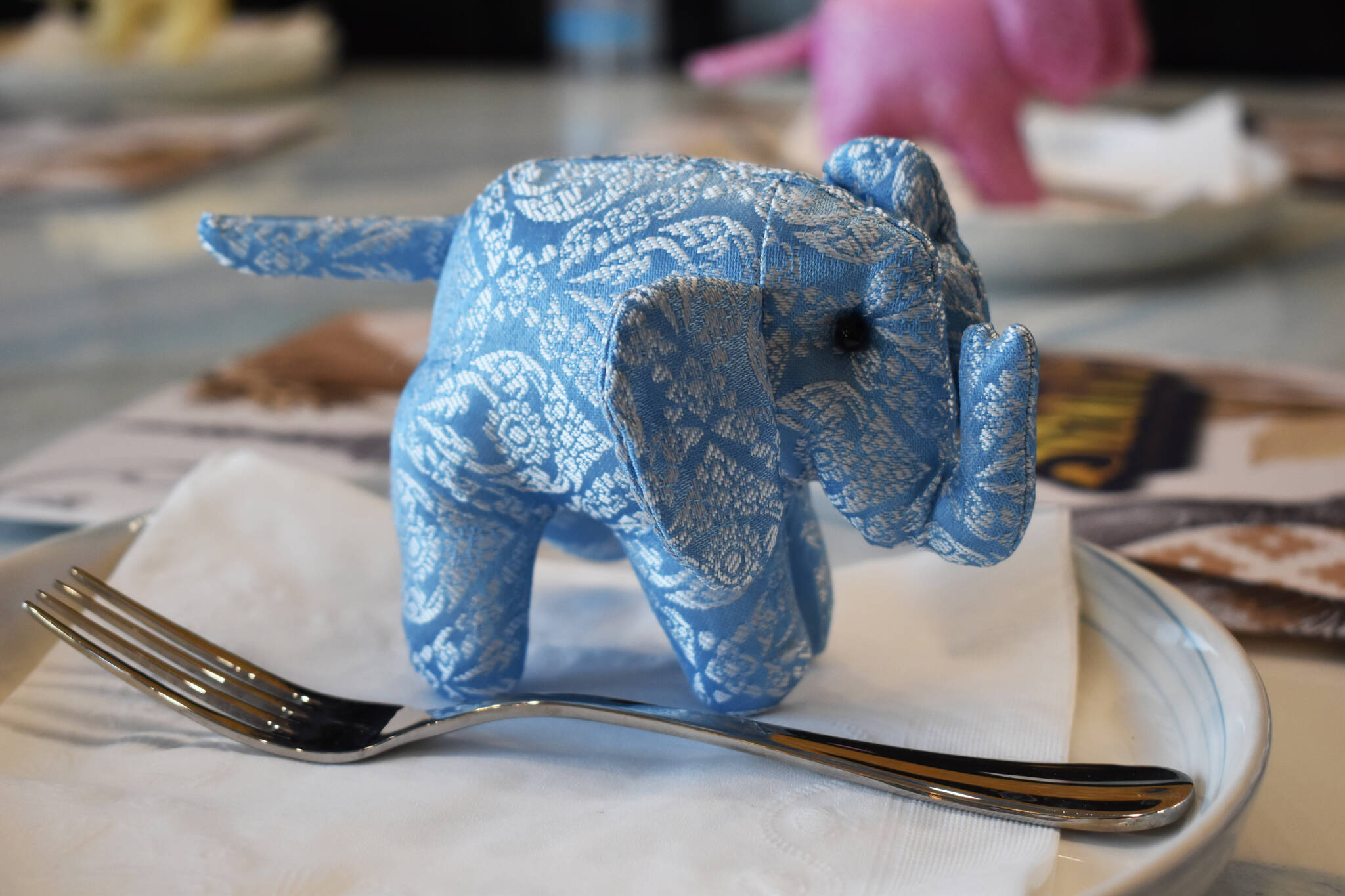 A small elephant sits on a plate with a fork at Siam Noodles and Food in Soldotna, Alaska, on Friday, April 7, 2023. (Jake Dye/Peninsula Clarion)