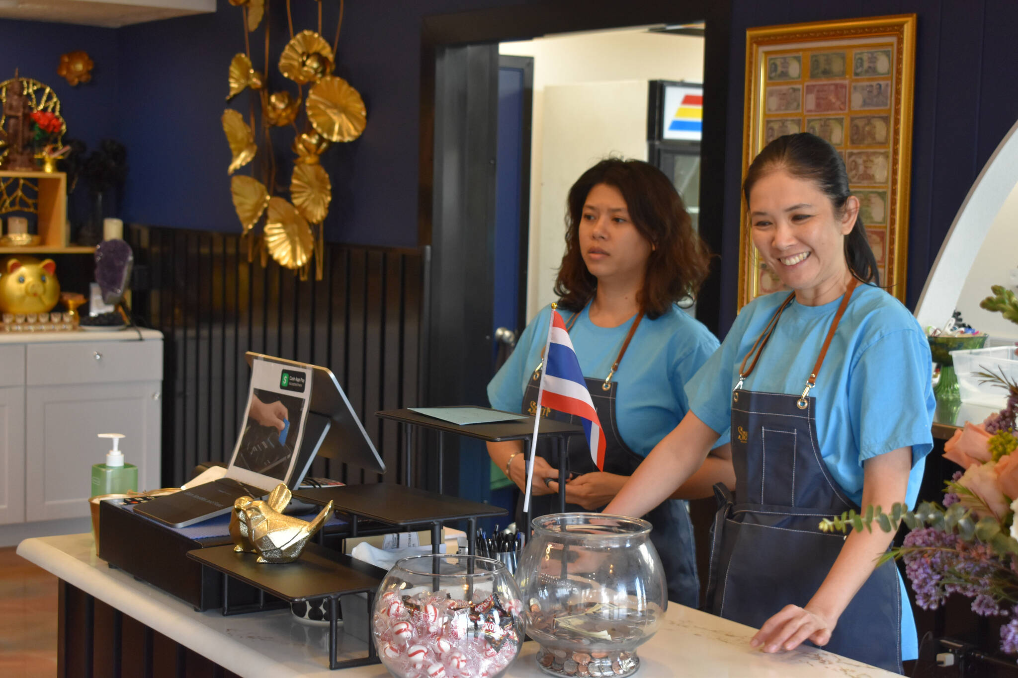 Suwannasa Piwon, right, stands at the counter and greets guests during a soft opening held Friday, April 7, 2023, at Siam Noodles and Food in Soldotna, Alaska. (Jake Dye/Peninsula Clarion)