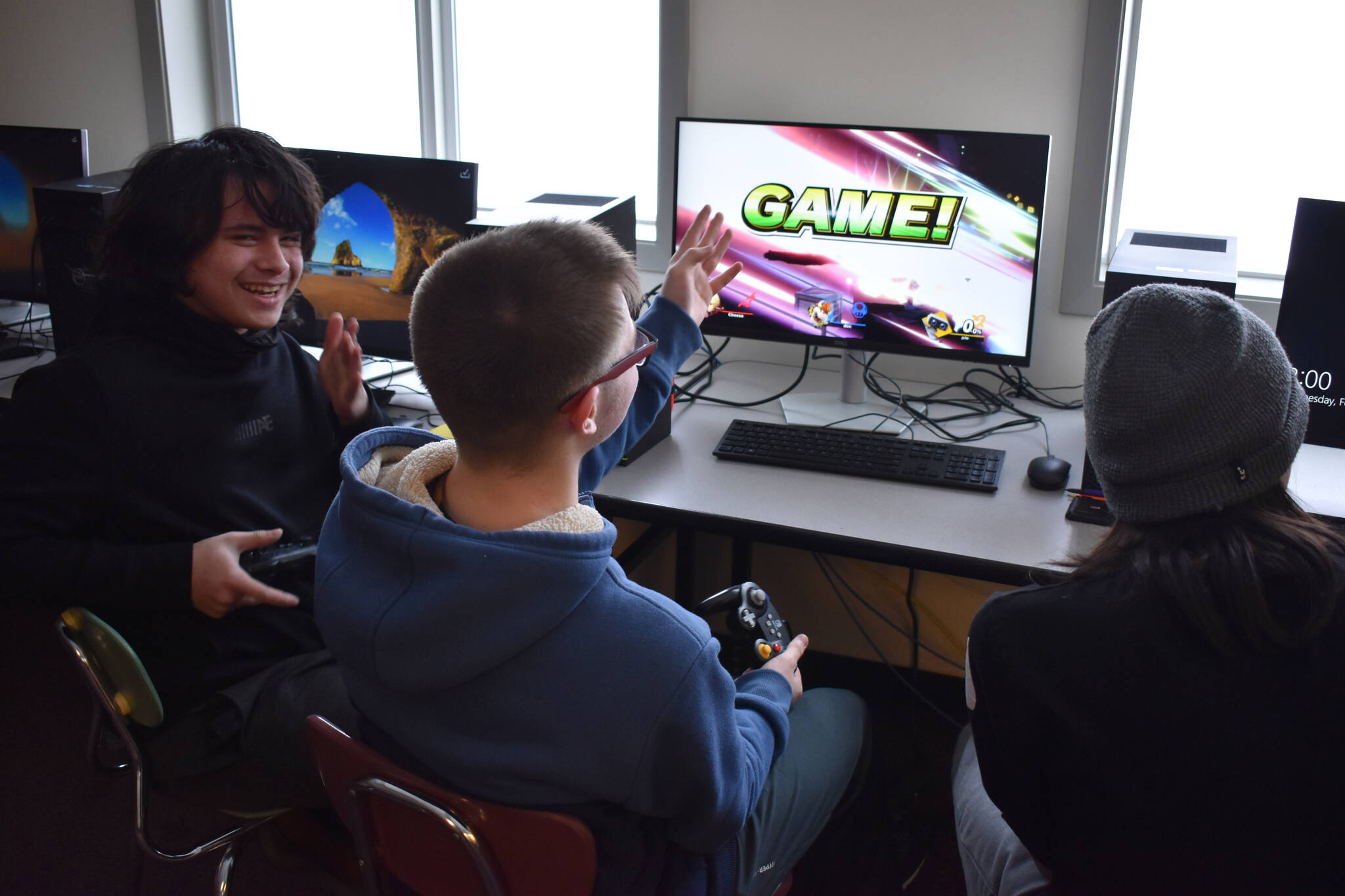 Eli Castro, Blake Gillis and Kaizen Fuller either celebrate victory or cry out in defeat at the end of a practice match of Super Smash Bros. Ultimate played ahead of a scheduled game at Kenai Central High School in Kenai, Alaska, on Wednesday, Feb. 15, 2023. (Jake Dye/Peninsula Clarion)