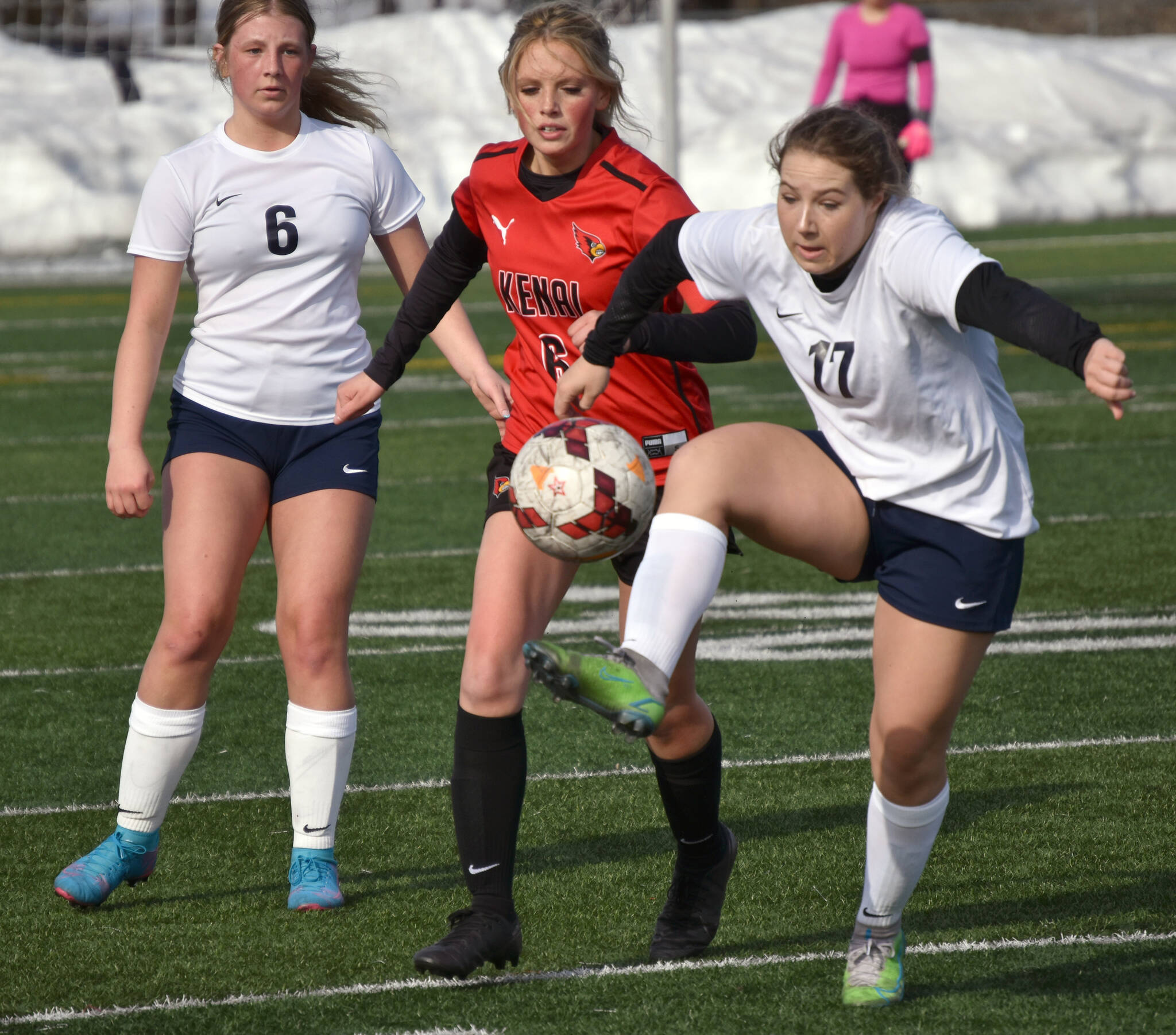Soldotna’s Liberty Miller controls the ball in front of Kenai Central’s Kori Moore and Soldotna’s Alex Lee on Tuesday, April 18, 2023, at Ed Hollier Field at Kenai Central High School in Kenai, Alaska. (Photo by Jeff Helminiak/Peninsula Clarion)