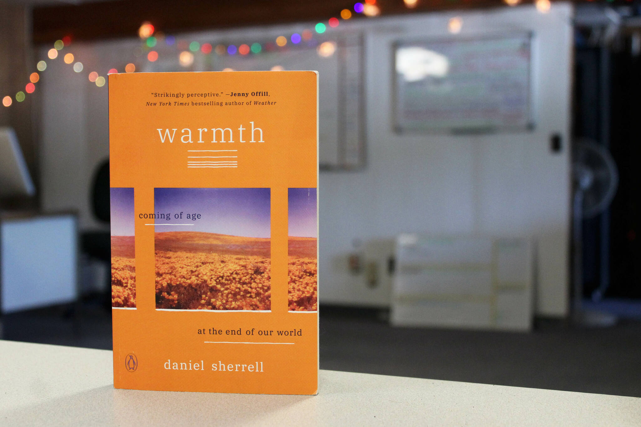 A copy of Daniel Sherrell’s “Warmth: Coming of Age at the End of our World” sits on a desk in the Peninsula Clarion building on Thursday March 30, 2023, in Kenai, Alaska. (Ashlyn O’Hara/Peninsula Clarion)
