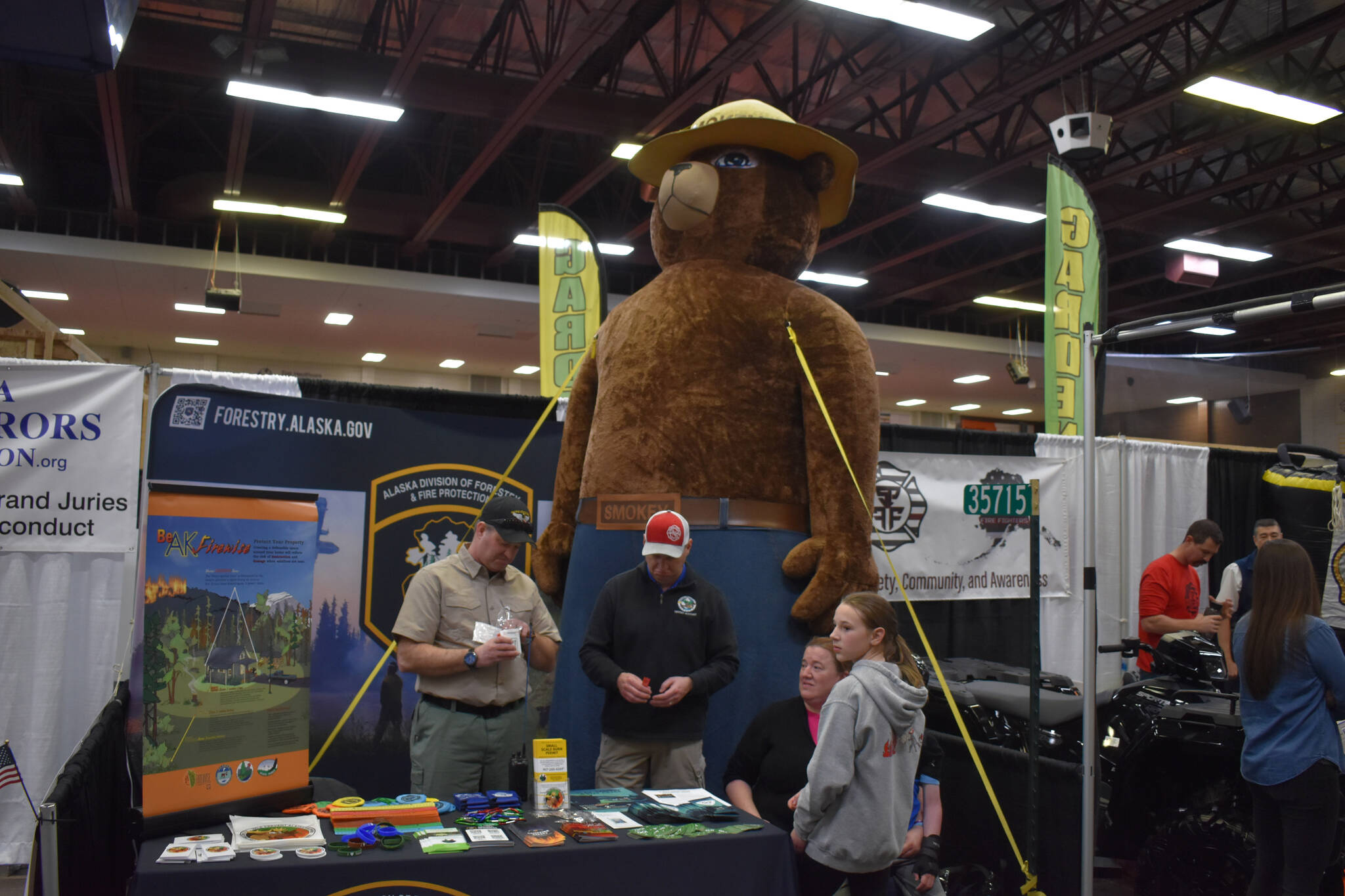 Alaska Division of Forestry & Fire Protection staff stand with Smokey Bear at the 43rd Annual Home Show hosted by the Kenai Peninsula Builders Association on Sunday, April 23, 2023, at the Soldotna Regional Sports Complex in Soldotna, Alaska. (Jake Dye/Peninsula Clarion)