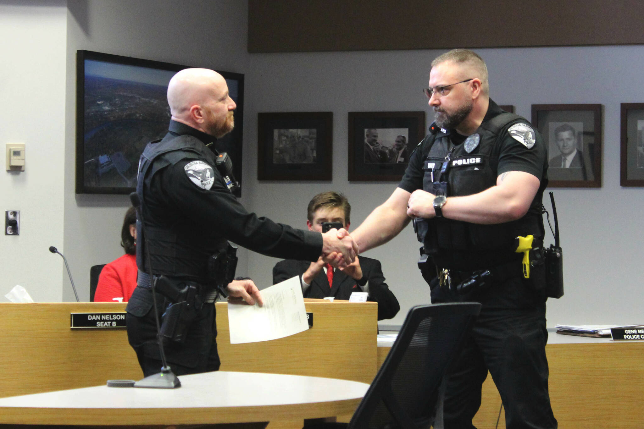 Soldotna Police Chief Gene Meek, left, presents Officer David Bower with a Lifesaver Award during a Soldotna City Council meeting on Wednesday, April 26, 2023, in Soldotna, Alaska. (Ashlyn O’Hara/Peninsula Clarion)