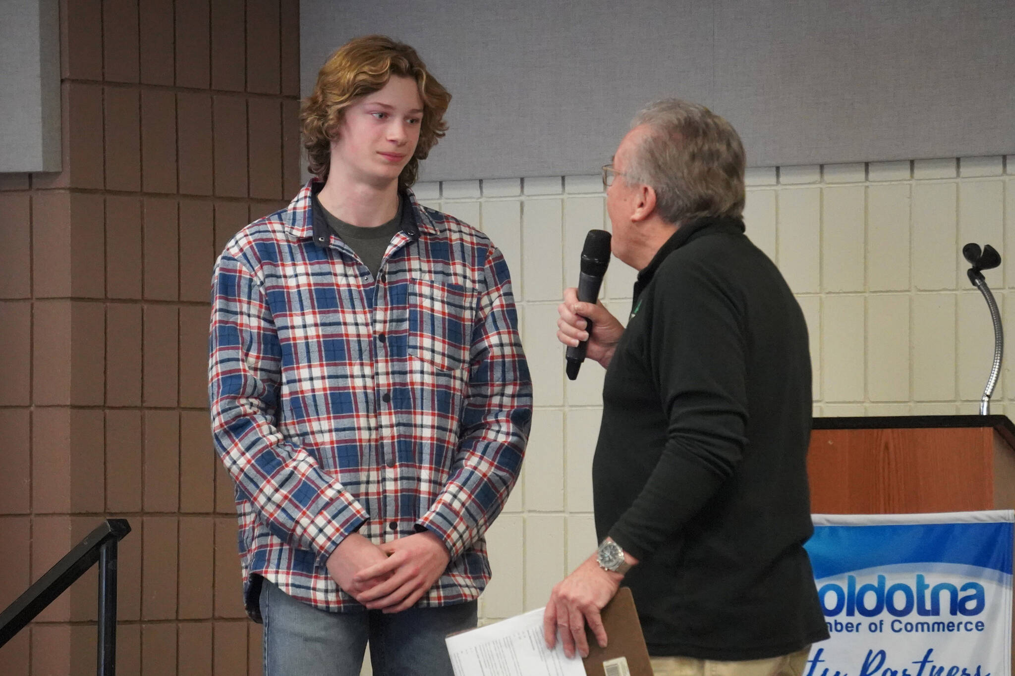 Matthew Schiling, of Cook Inlet Academy, is introduced by Merrill Sikorski at the Caring for the Kenai Awards Celebration held during a Joint Chamber Luncheon on Wednesday, May 3, 2023, at the Soldotna Regional Sports Complex in Soldotna, Alaska. (Jake Dye/Peninsula Clarion)